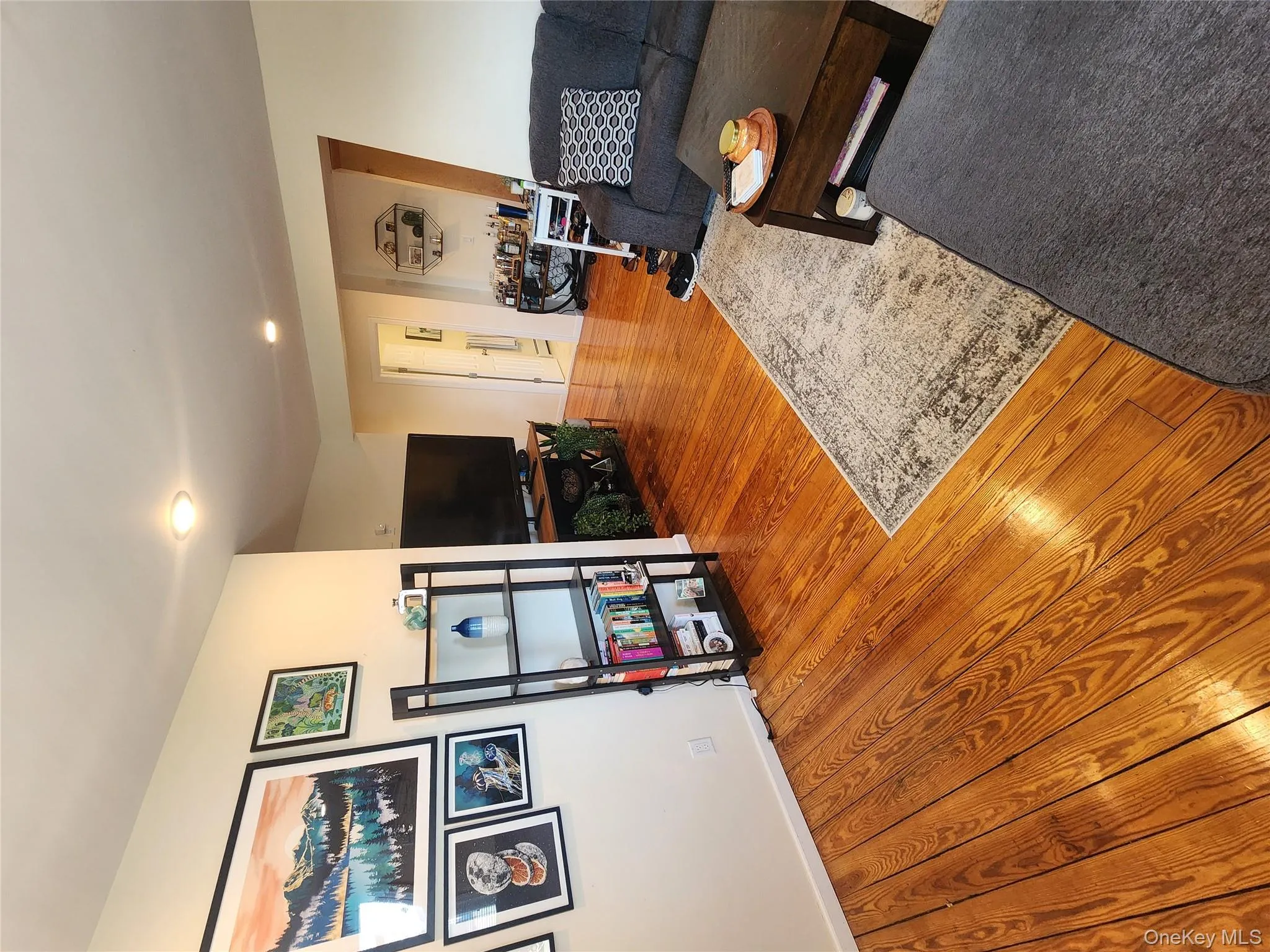 Living area featuring wood finished floors, recessed lighting, and baseboards Living area featuring wood finished floors, recessed lighting, and baseboards