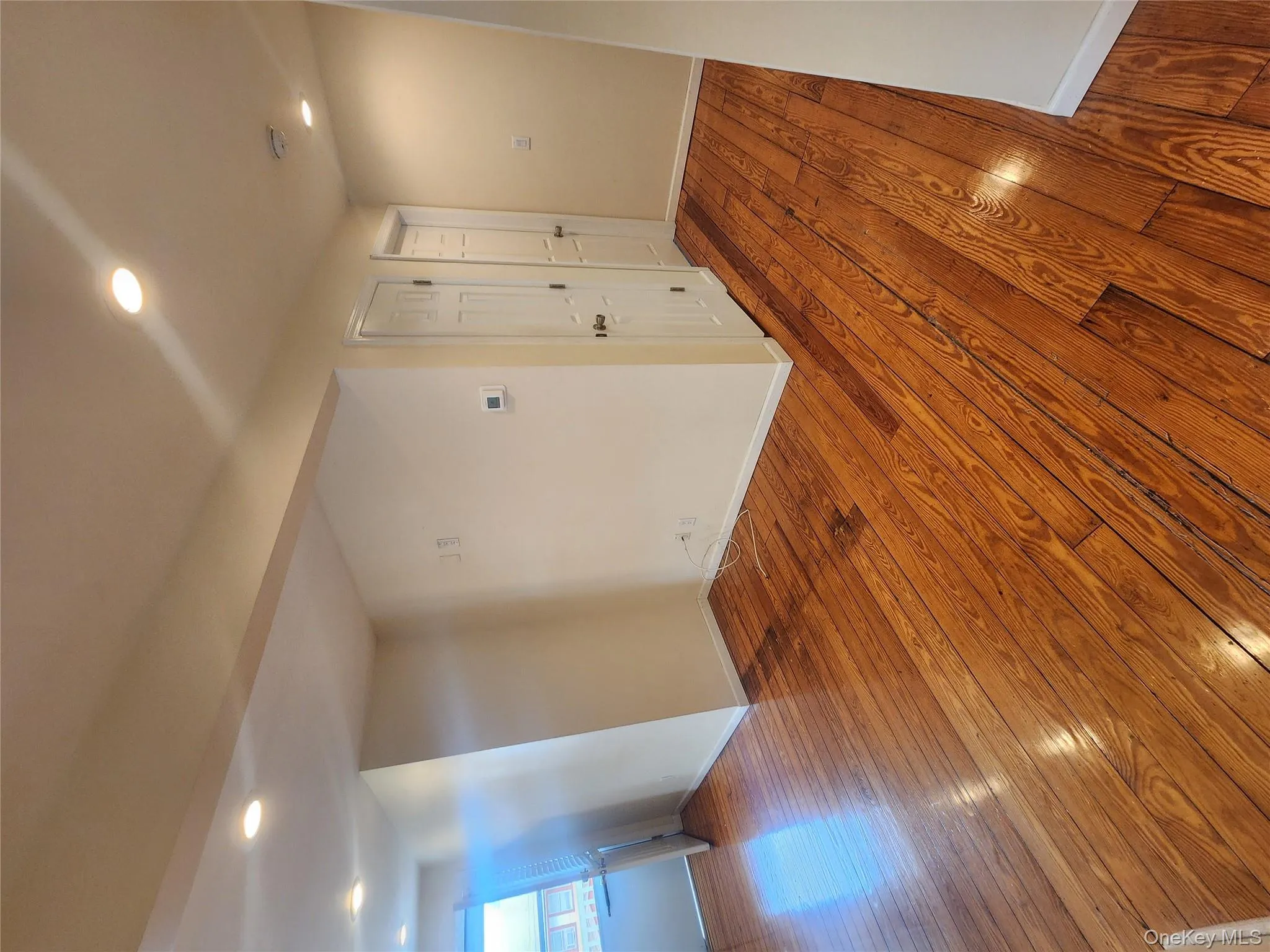 Empty room with wood-type flooring, recessed lighting, and a smoke detector Empty room with wood-type flooring, recessed lighting, and a smoke detector