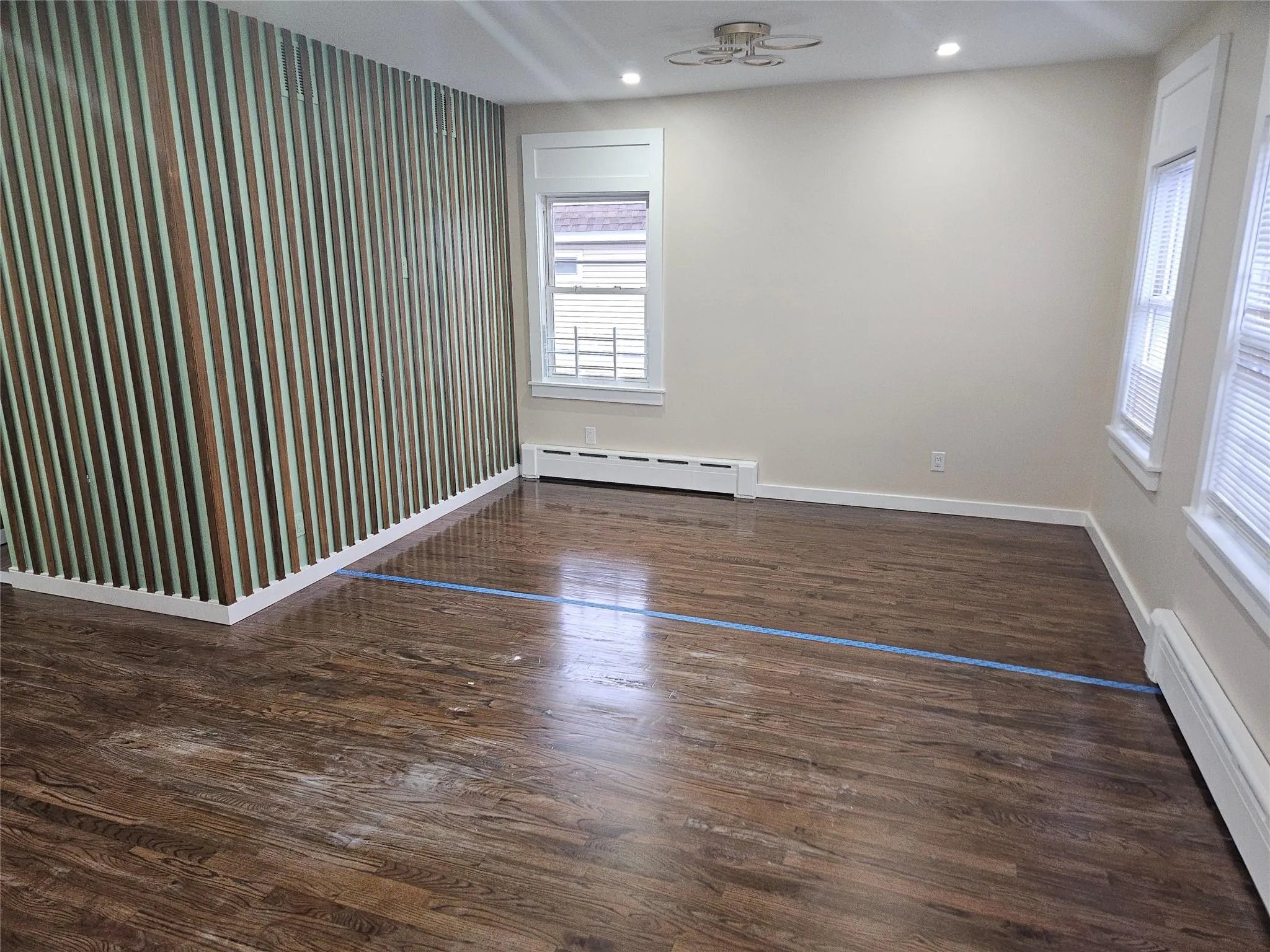 Spare room with a baseboard heating unit, a baseboard radiator, ceiling fan, baseboards, and wood finished floors Spare room with a baseboard heating unit, a baseboard radiator, ceiling fan, baseboards, and wood finished floors