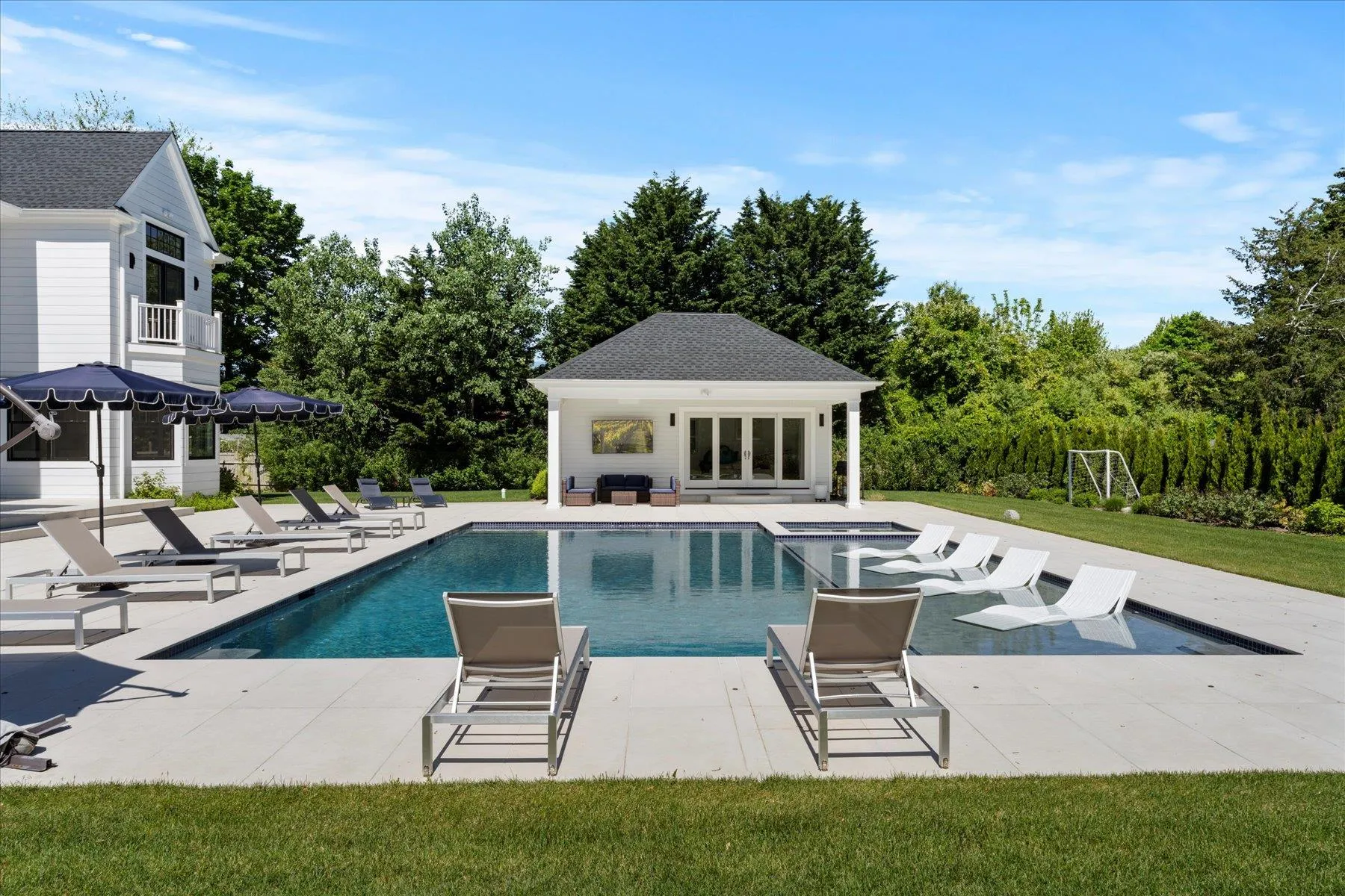 Swimming pool with an exterior structure, an outbuilding, and a patio Swimming pool with an exterior structure, an outbuilding, and a patio