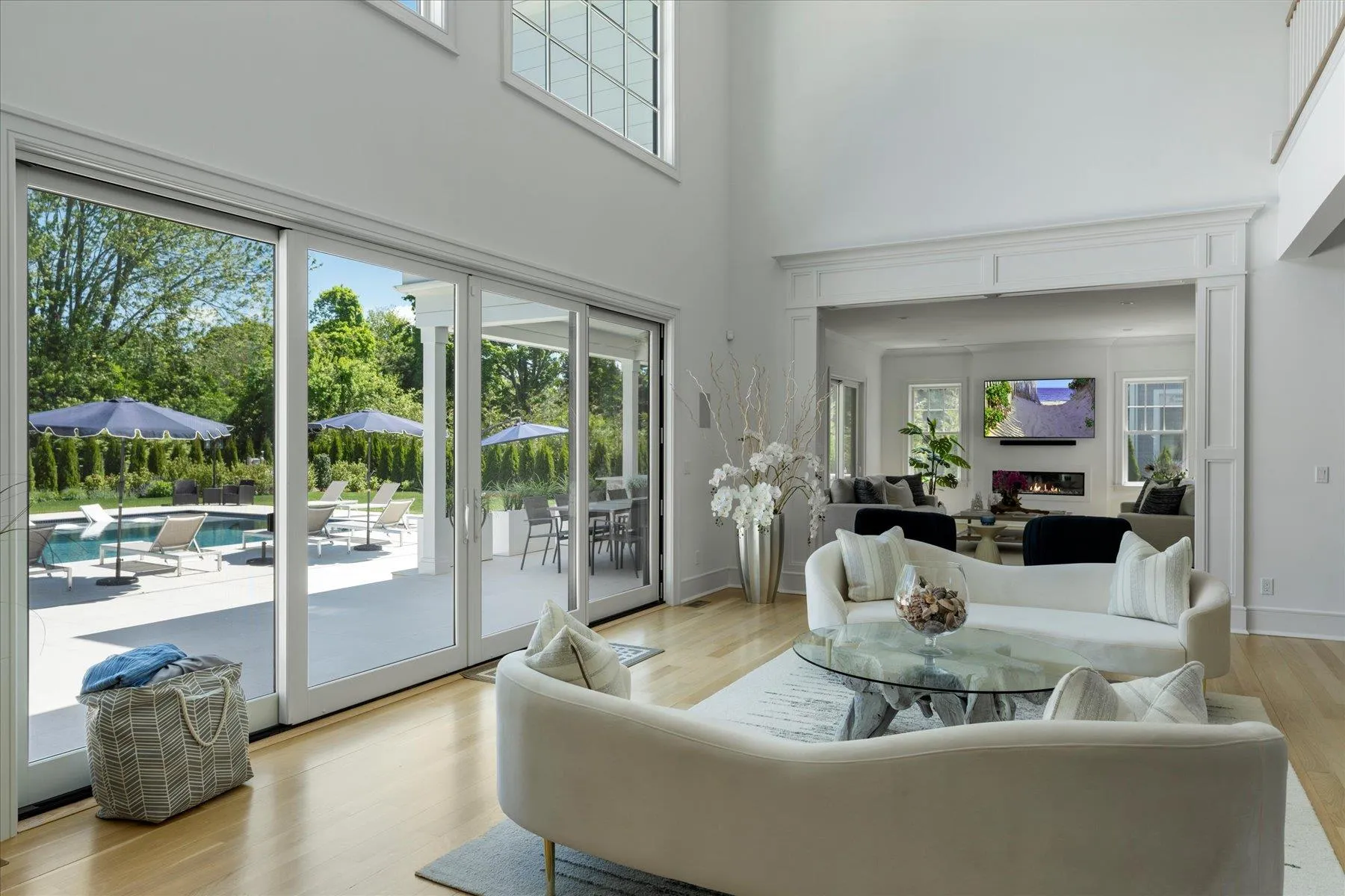 Living room featuring a towering ceiling, light wood-style floors, and baseboards Living room featuring a towering ceiling, light wood-style floors, and baseboards