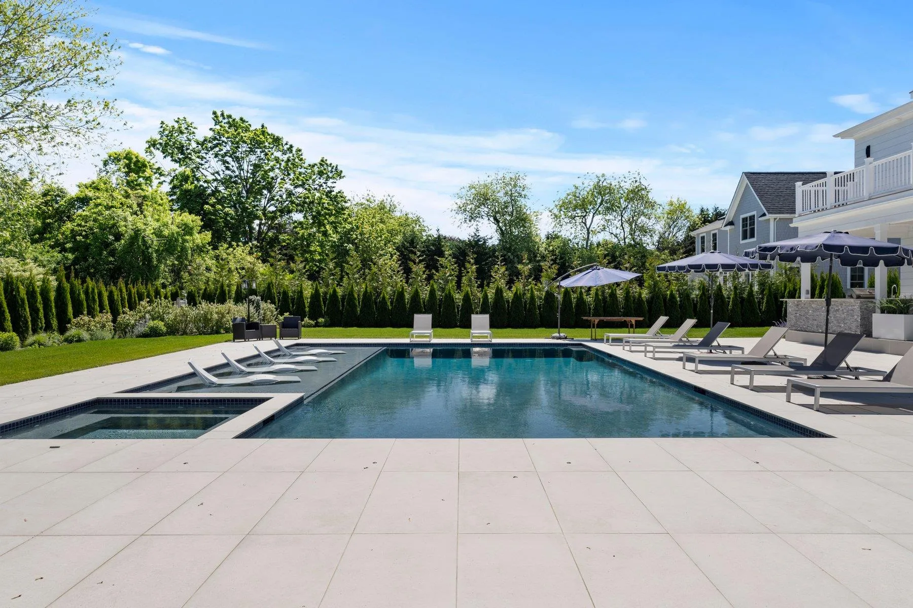 Outdoor pool with an in-ground hot tub, a patio area, and a yard Outdoor pool with an in-ground hot tub, a patio area, and a yard