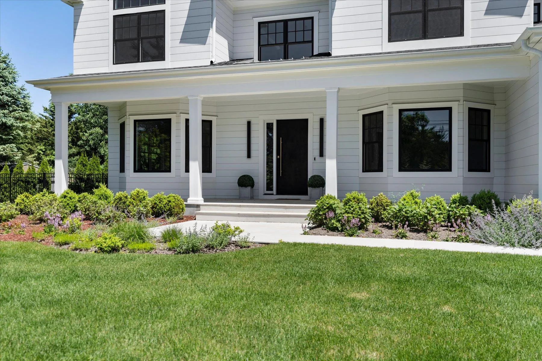 View of exterior entry featuring covered porch and a lawn View of exterior entry featuring covered porch and a lawn