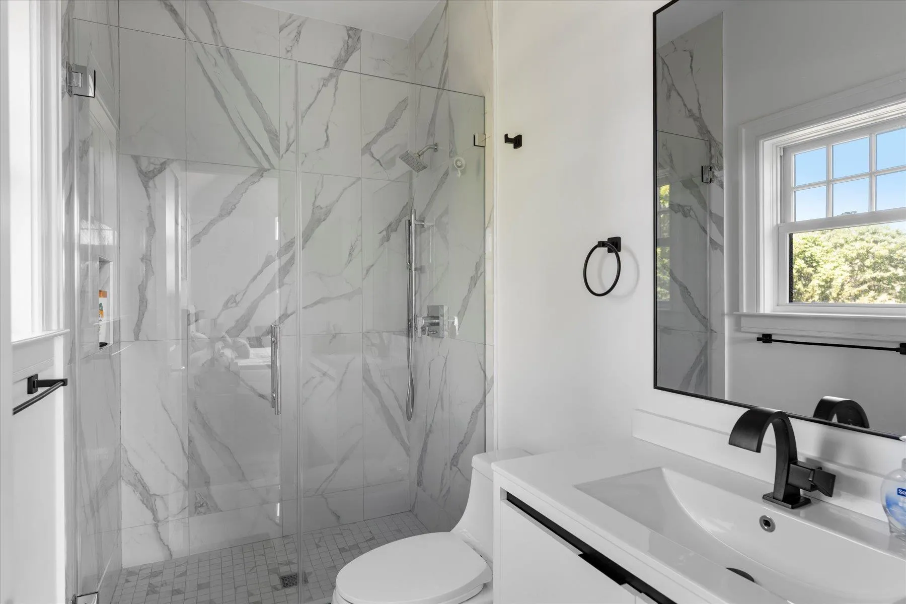 Full bathroom featuring a marble finish shower, vanity, and toilet Full bathroom featuring a marble finish shower, vanity, and toilet