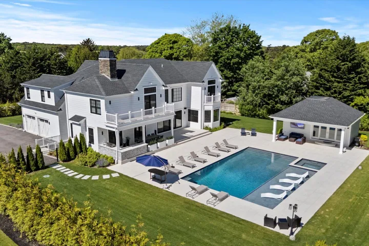 Rear view of property featuring a balcony, a lawn, an outbuilding, an outdoor hangout area, and a patio