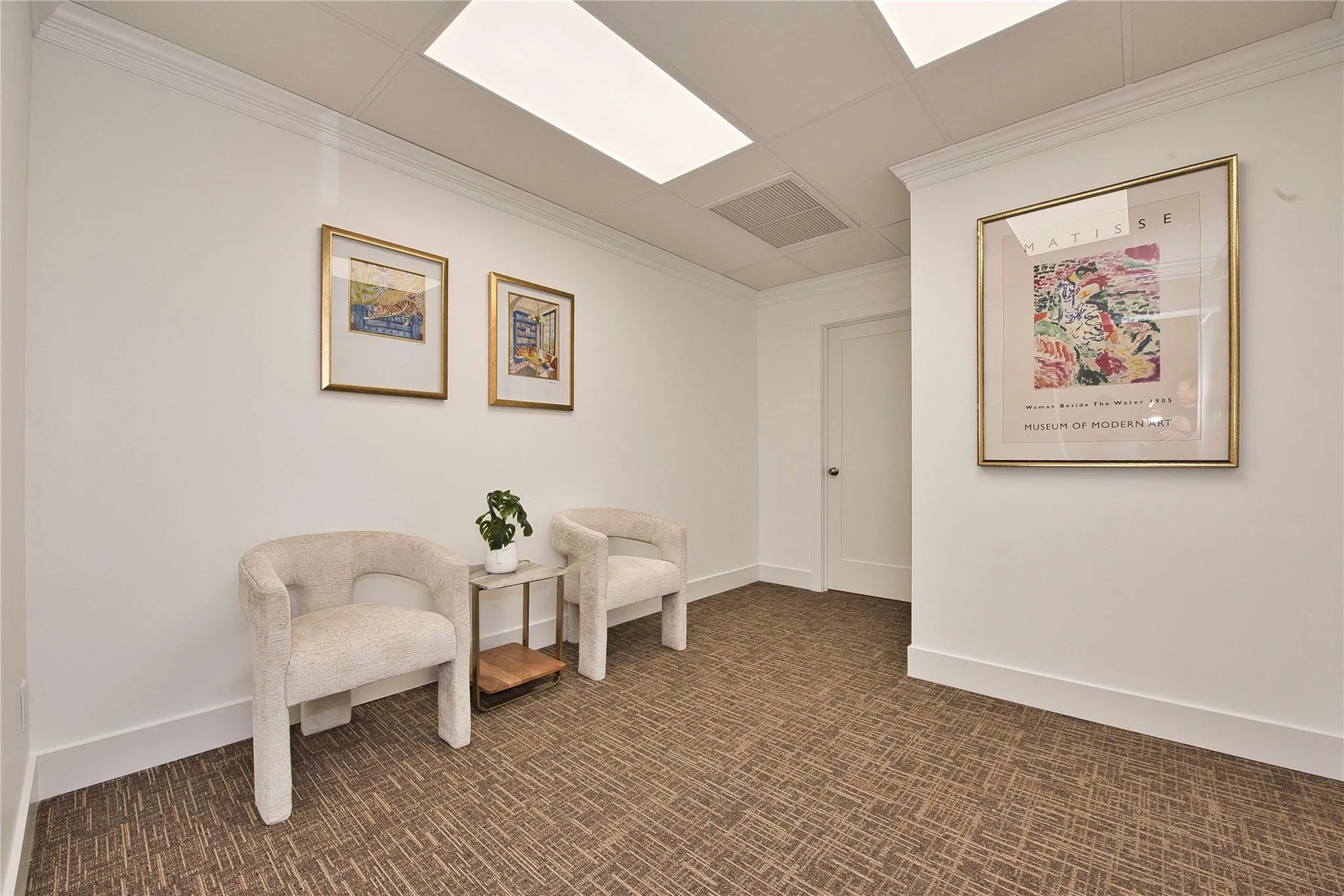 Living area featuring crown molding, dark carpet, and baseboards Living area featuring crown molding, dark carpet, and baseboards