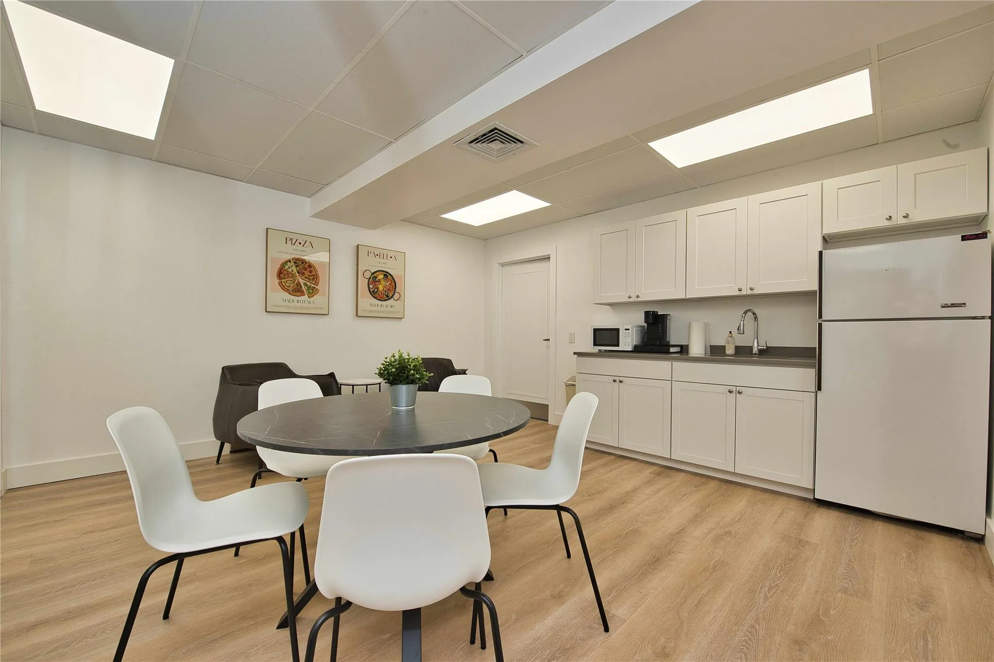 Dining area featuring light wood-type flooring, baseboards, and a drop ceiling Dining area featuring light wood-type flooring, baseboards, and a drop ceiling