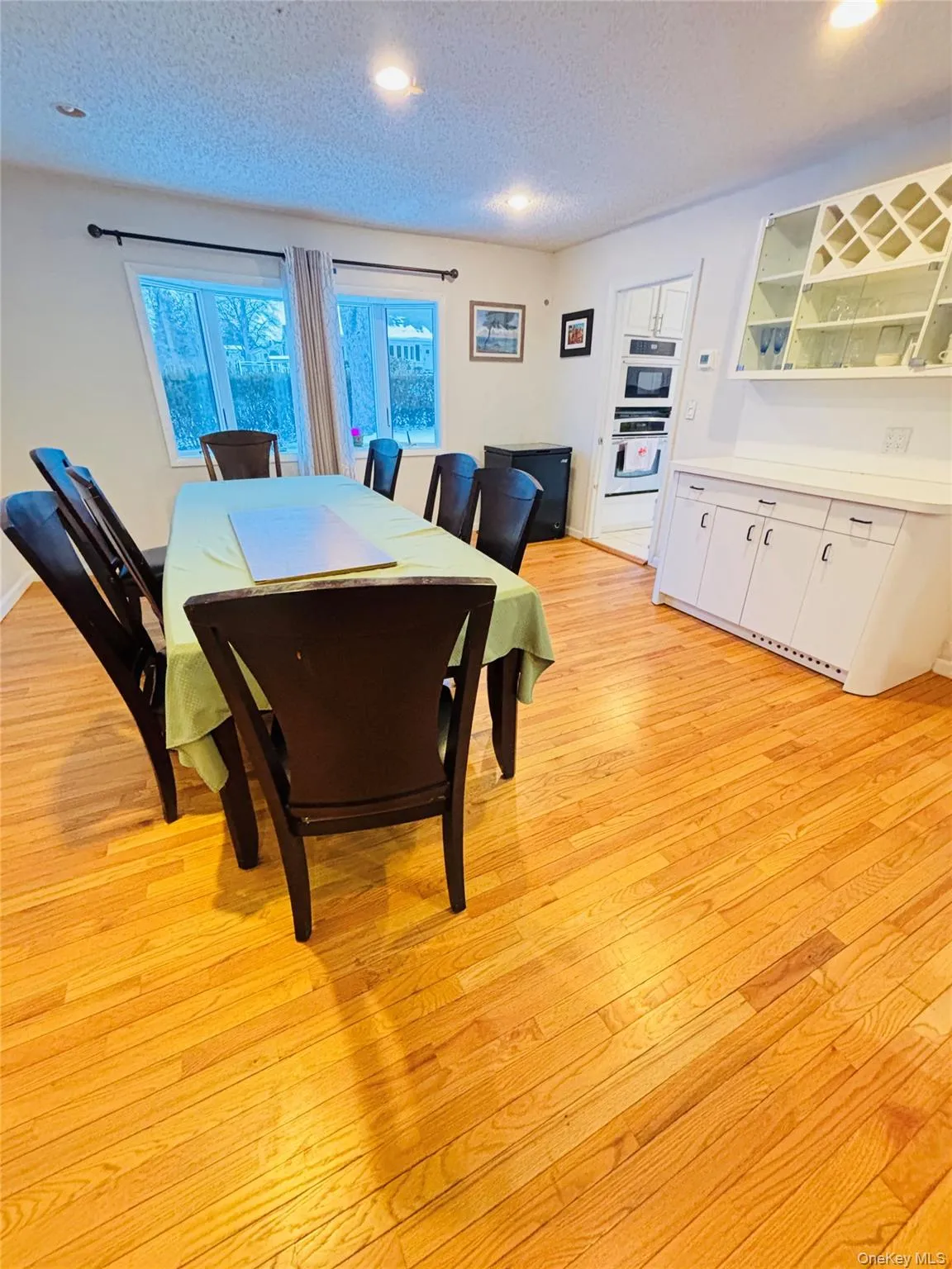 Dining area featuring a textured ceiling, recessed lighting, and light wood finished floors Dining area featuring a textured ceiling, recessed lighting, and light wood finished floors