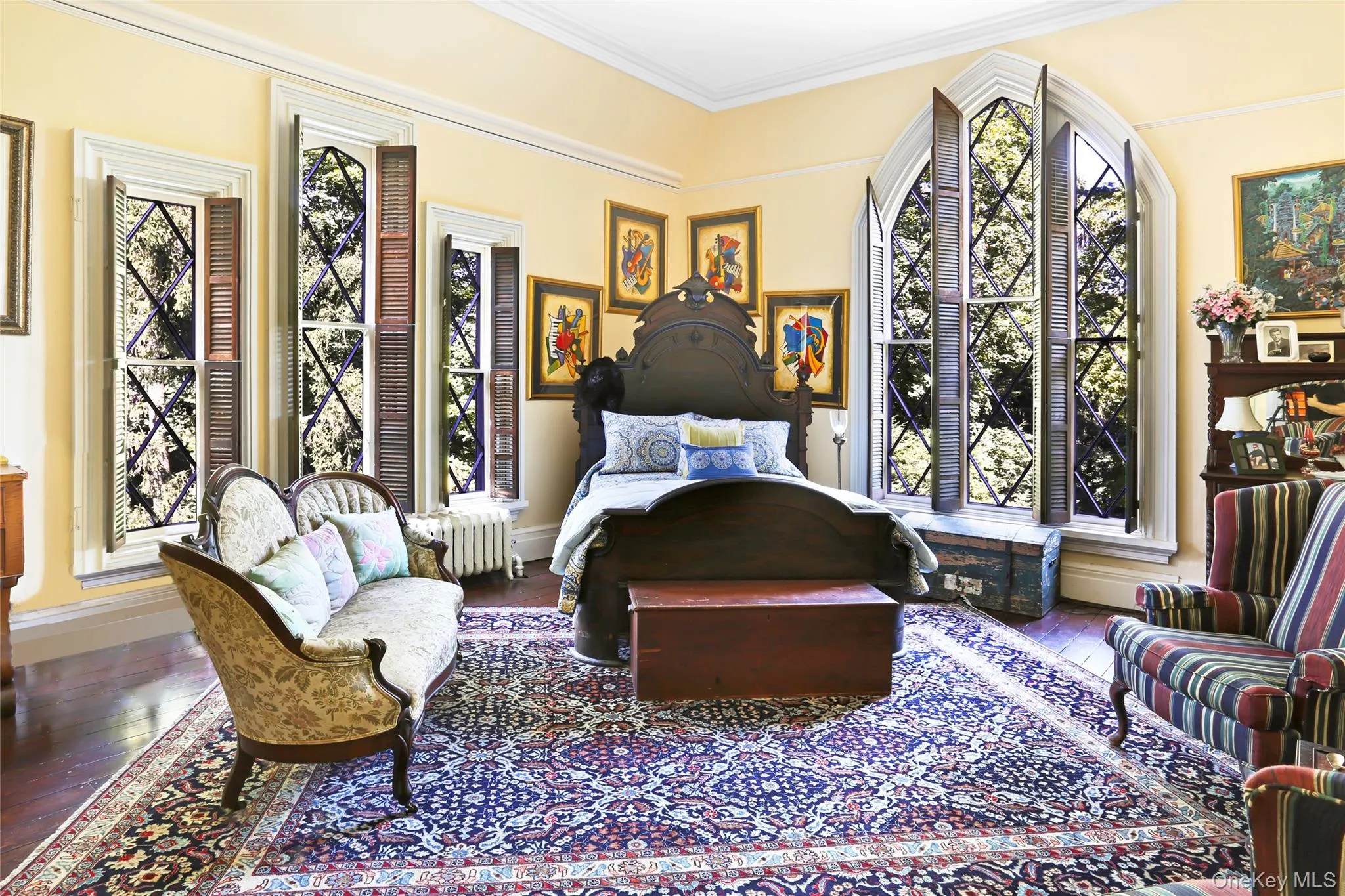 Bedroom with crown molding, wood-type flooring, and baseboards Bedroom with crown molding, wood-type flooring, and baseboards