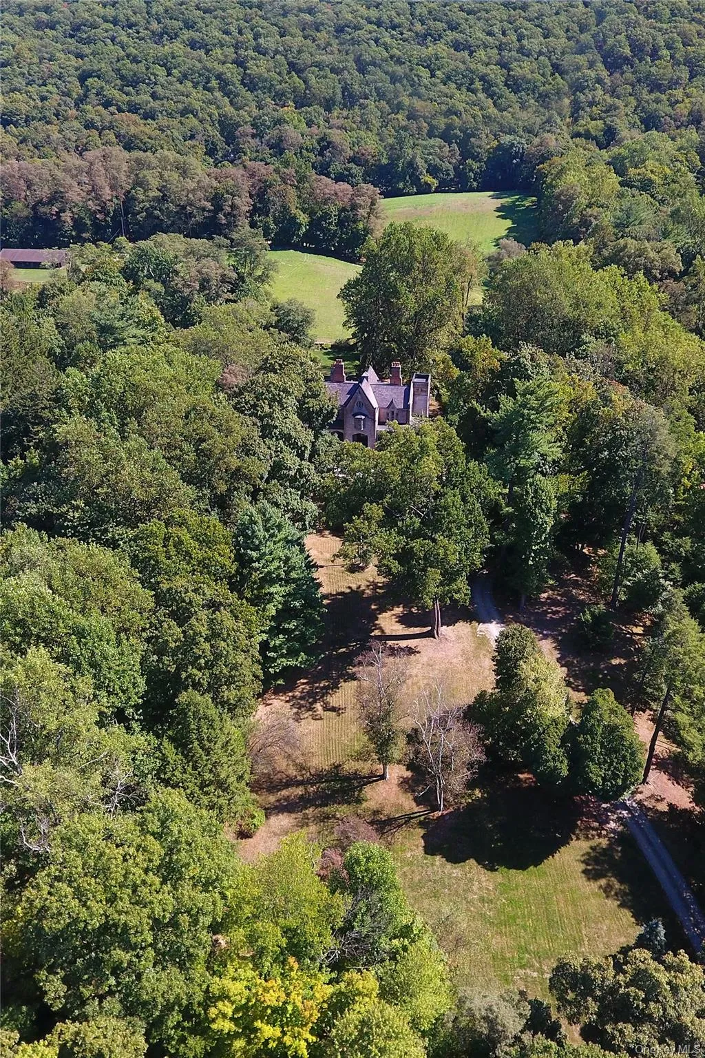 Aerial view of property and surrounding area with a forest Aerial view of property and surrounding area with a forest