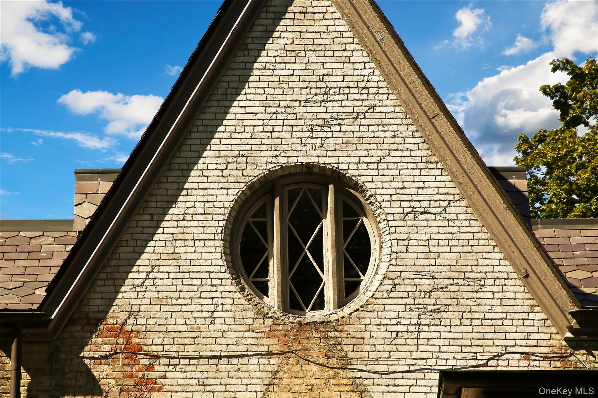 View of side of home with a shingled roof and brick siding View of side of home with a shingled roof and brick siding
