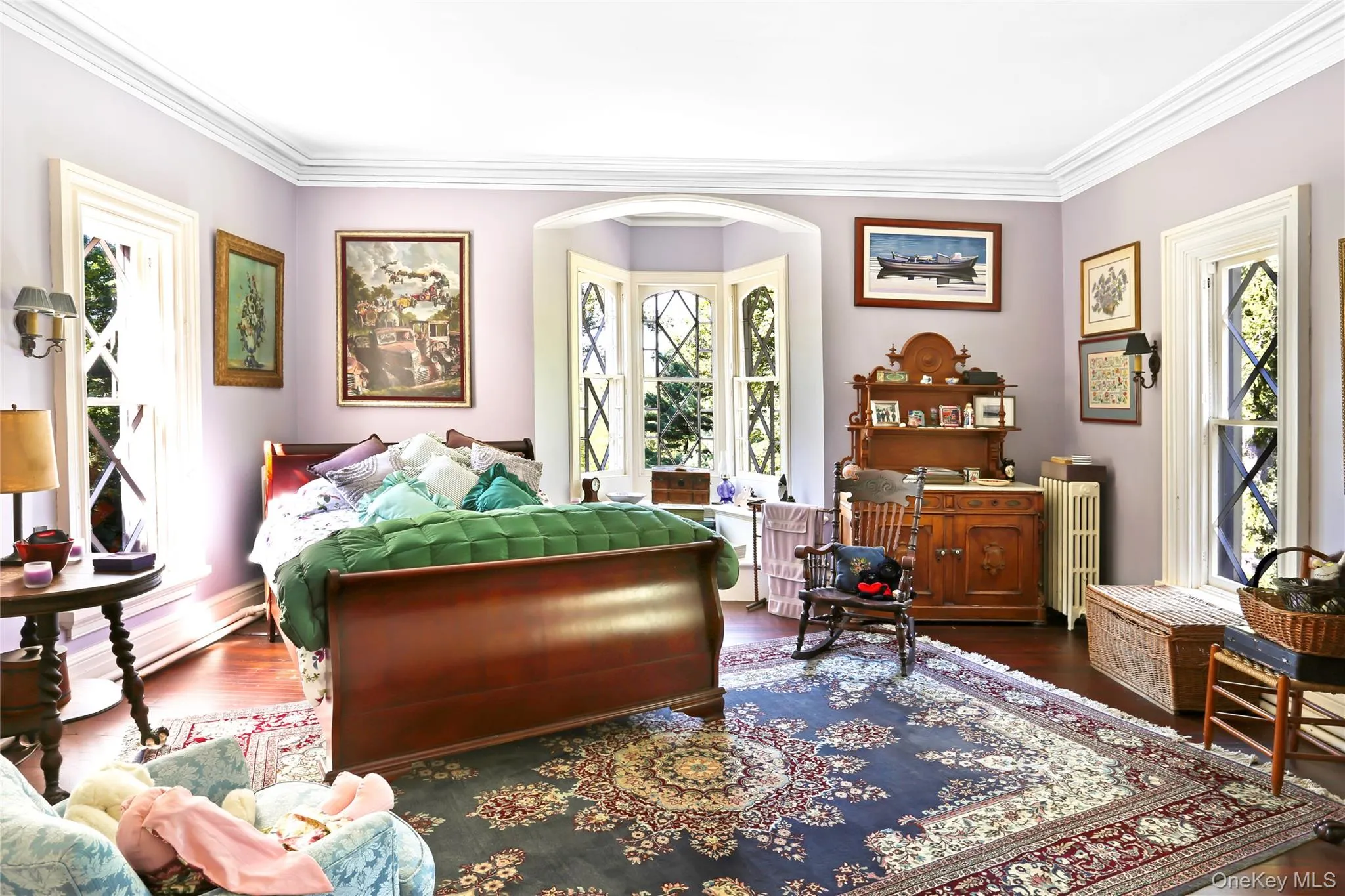 Bedroom with radiator, crown molding, wood finished floors, and arched walkways Bedroom with radiator, crown molding, wood finished floors, and arched walkways