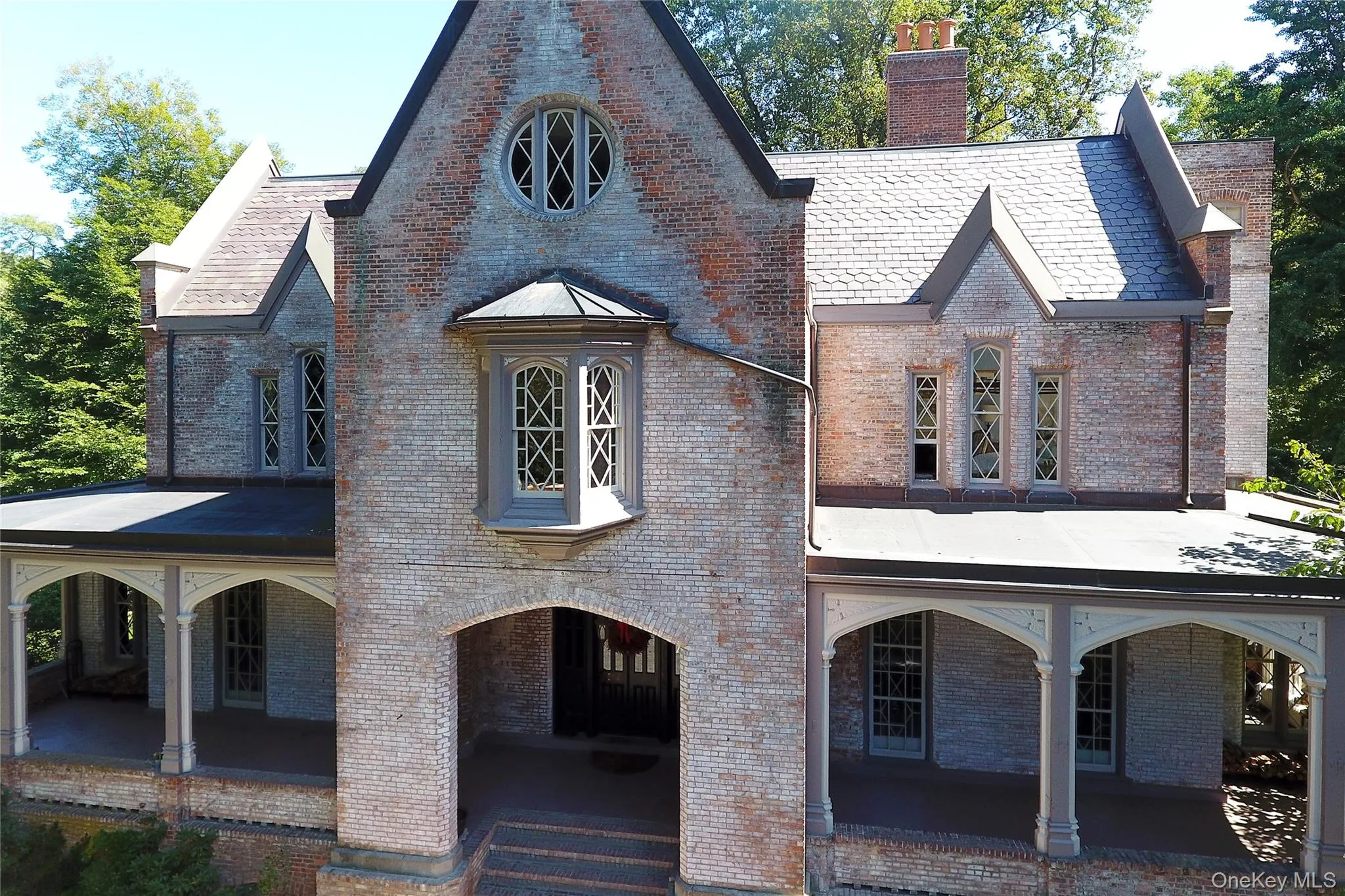 View of front facade featuring covered porch, a chimney, and brick siding View of front facade featuring covered porch, a chimney, and brick siding