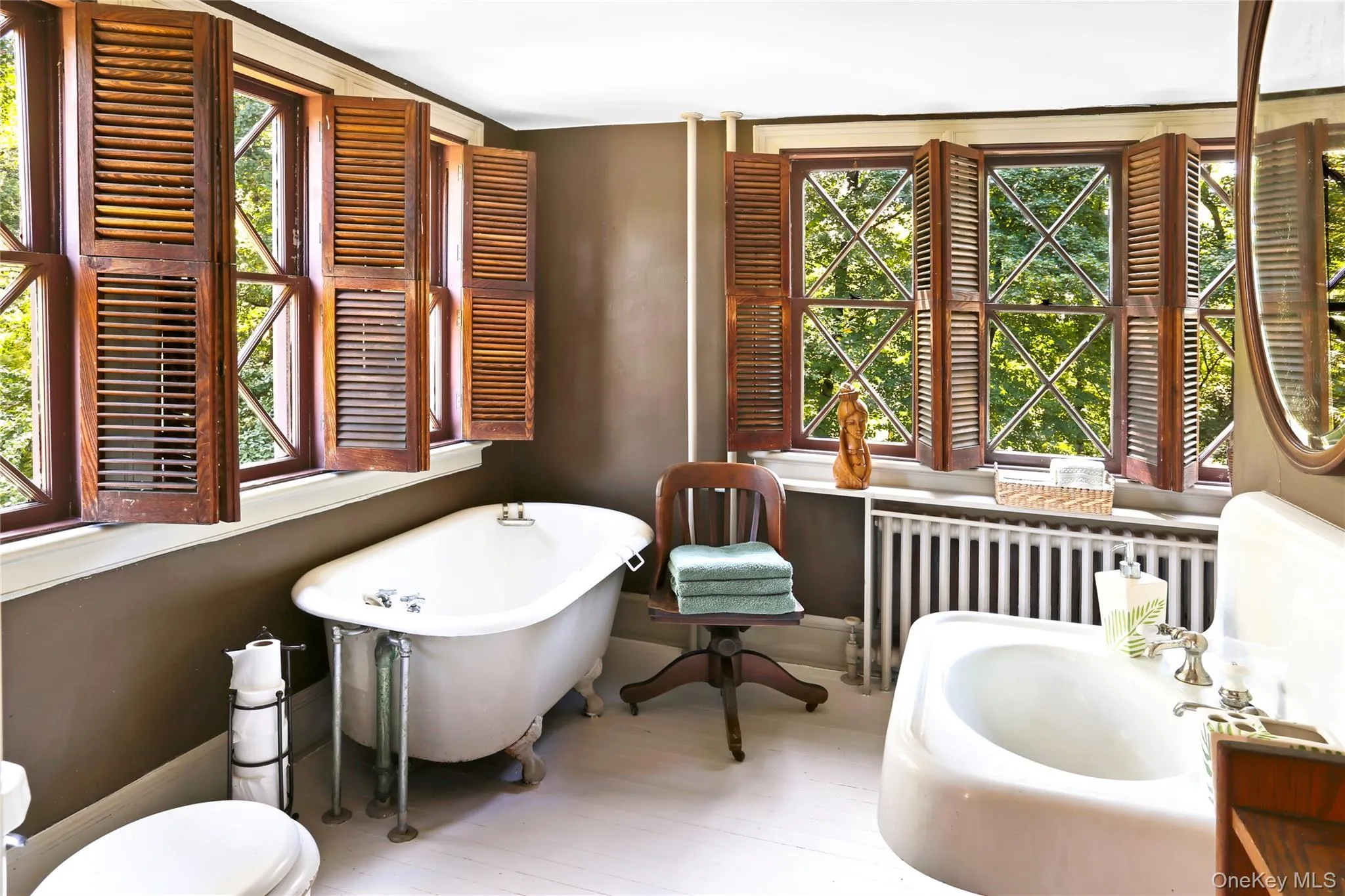 Bathroom with radiator heating unit, a freestanding bath, and wood finished floors Bathroom with radiator heating unit, a freestanding bath, and wood finished floors