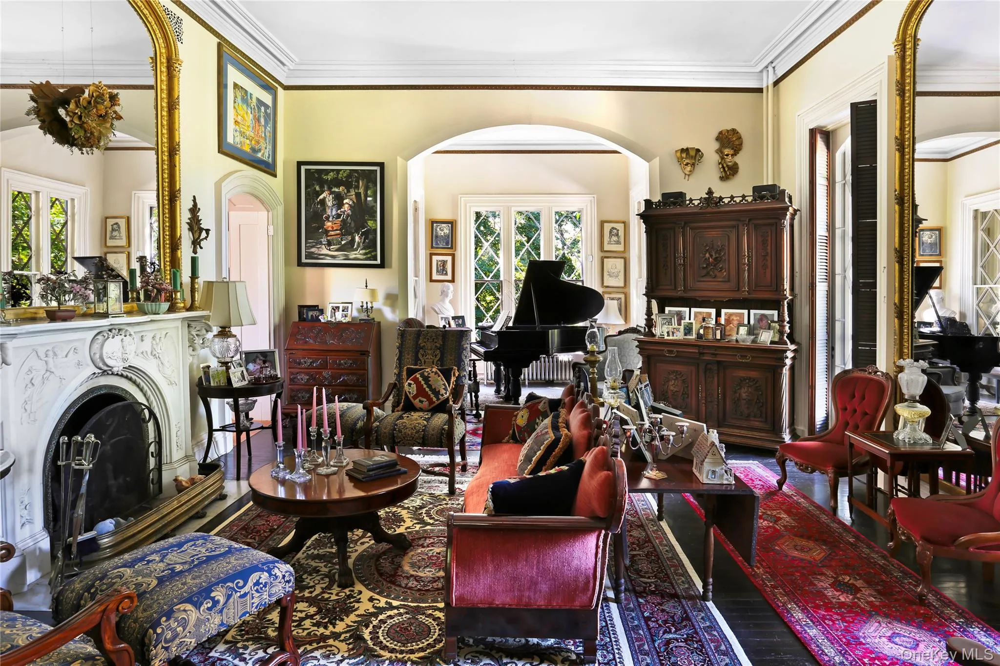 Sitting room featuring arched walkways, crown molding, plenty of natural light, and a fireplace with raised hearth Sitting room featuring arched walkways, crown molding, plenty of natural light, and a fireplace with raised hearth