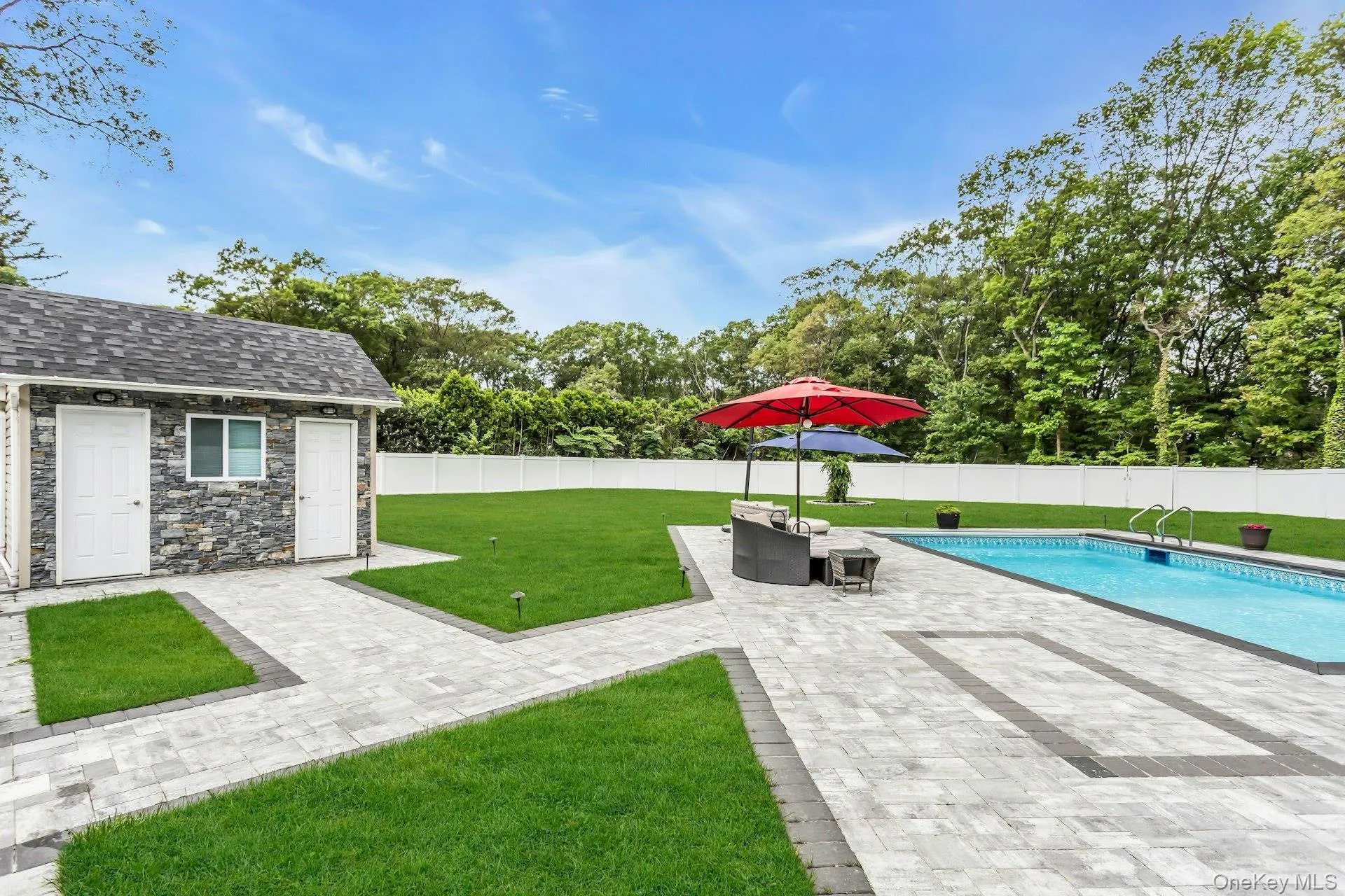 View of yard with a patio area, an outdoor structure, and view of wooded area View of yard with a patio area, an outdoor structure, and view of wooded area