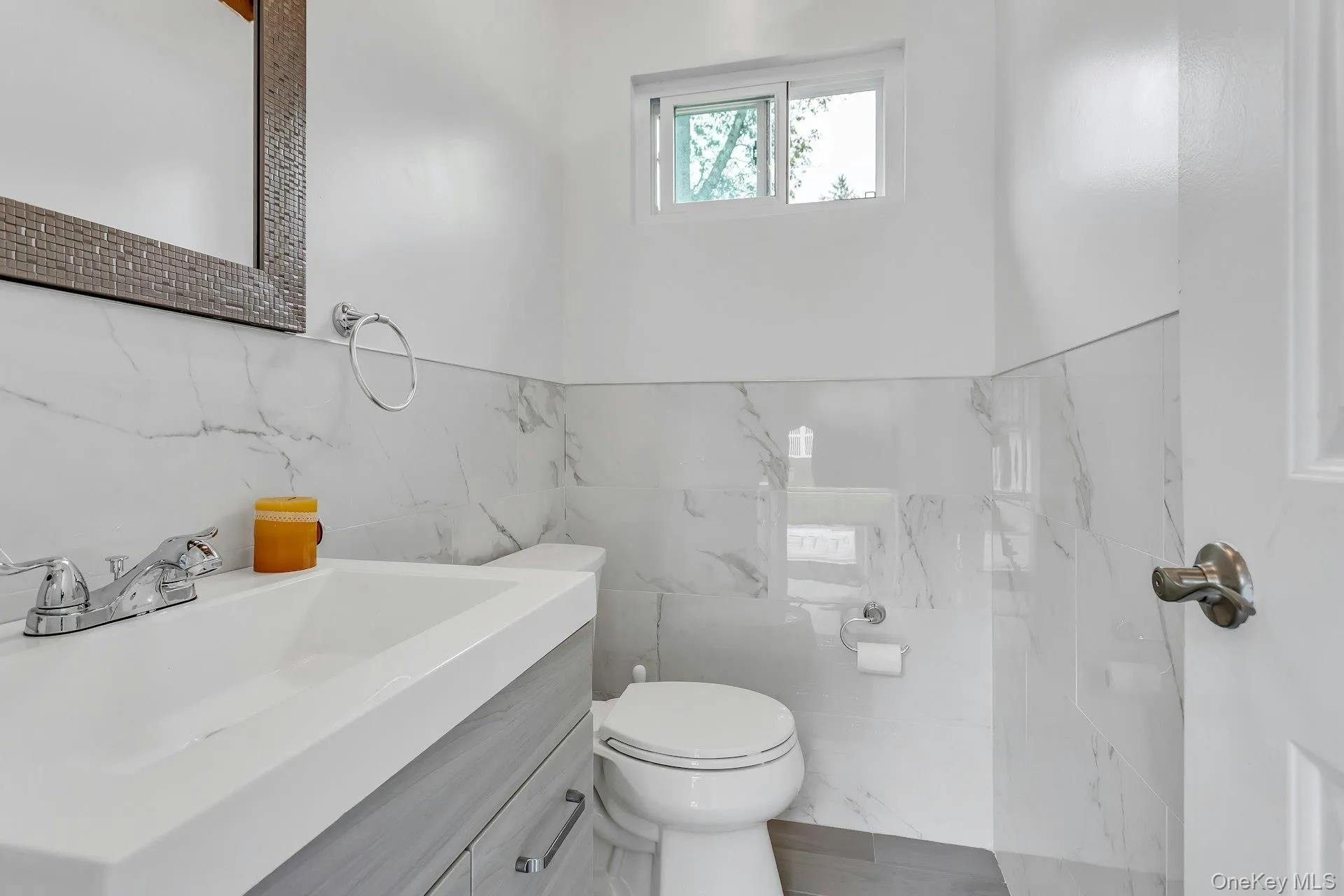 Bathroom featuring tile walls, vanity, and toilet Bathroom featuring tile walls, vanity, and toilet