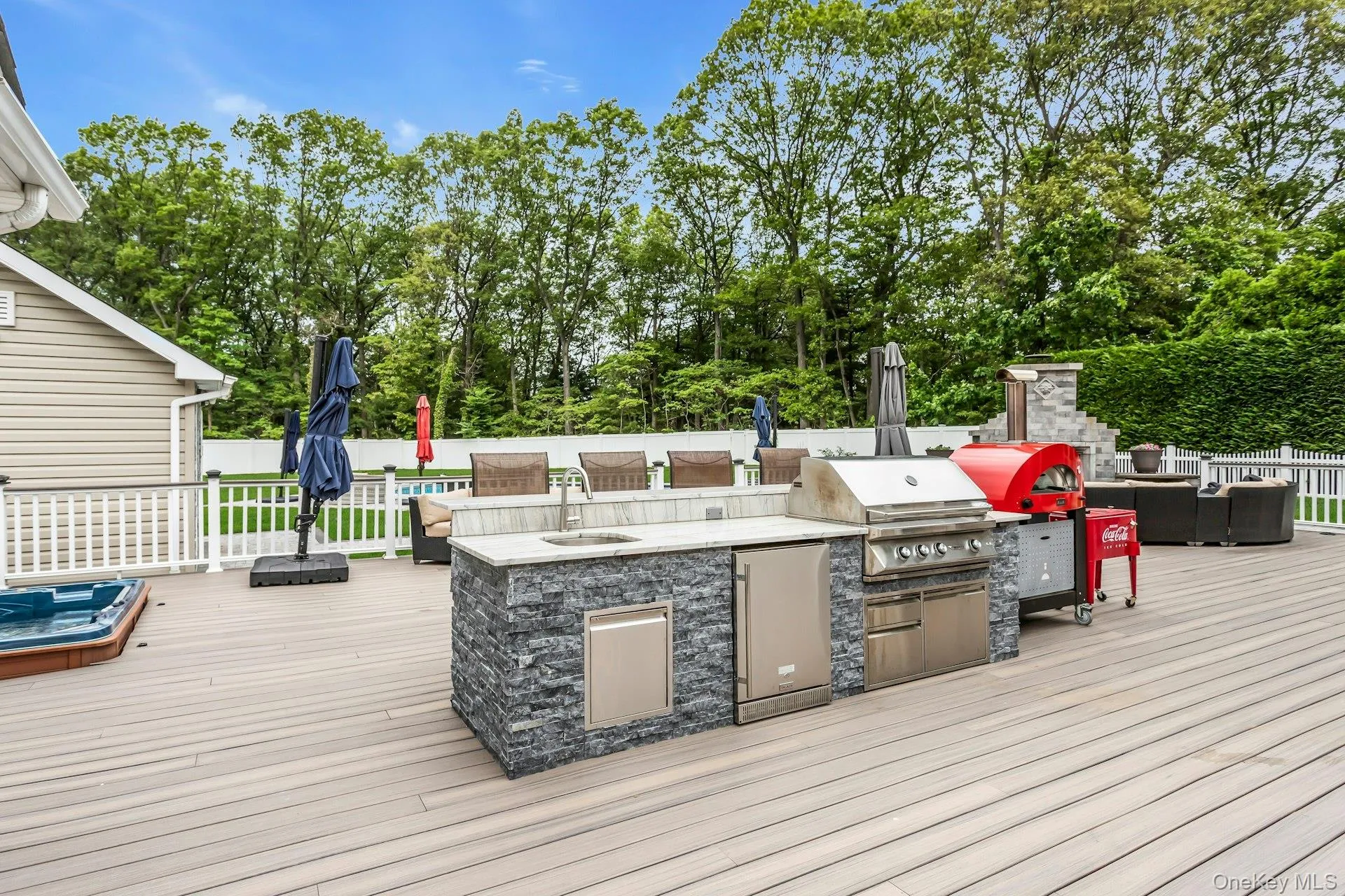 Deck featuring a sink, view of wooded area, and an outdoor living space Deck featuring a sink, view of wooded area, and an outdoor living space