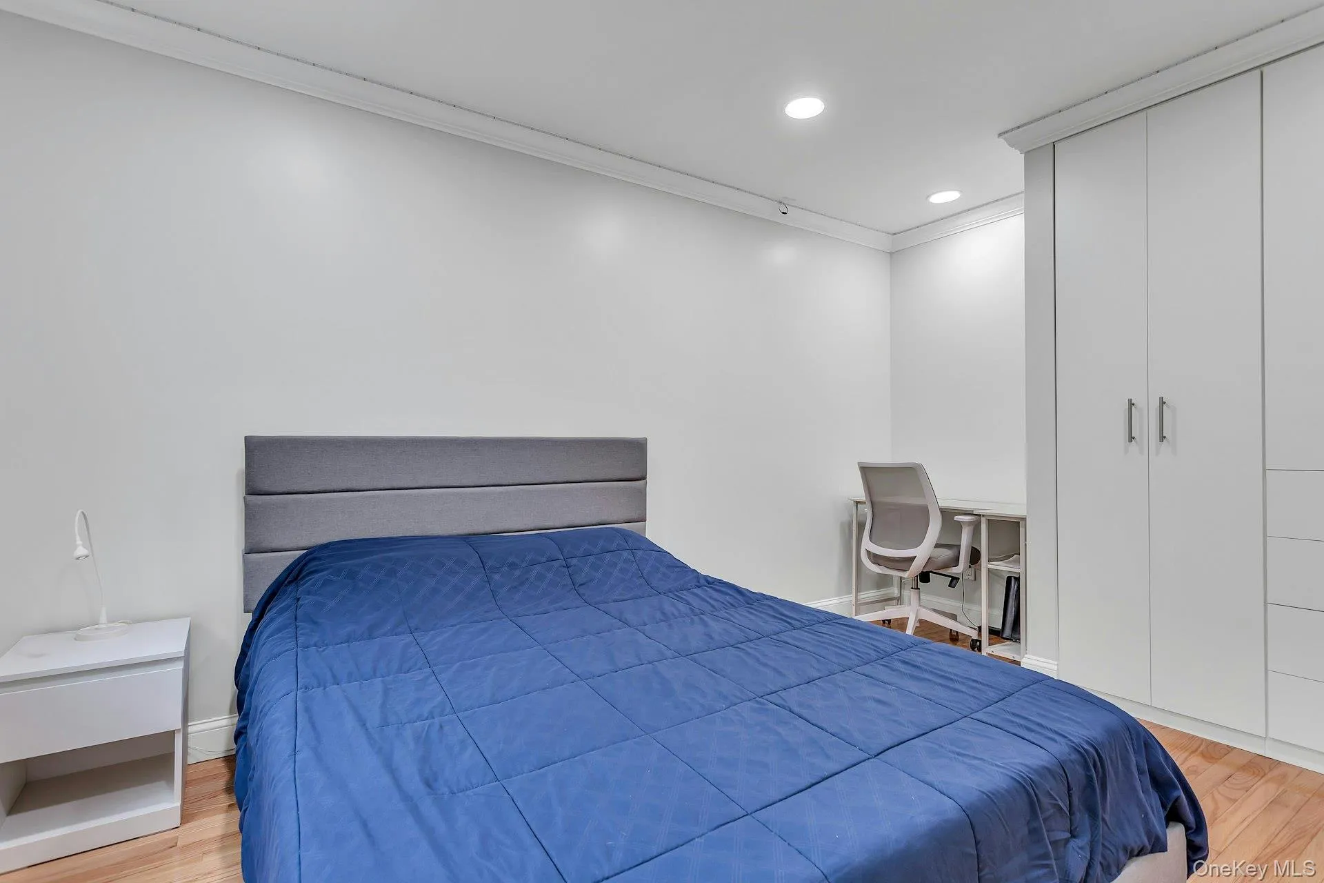 Bedroom featuring ornamental molding, light wood-style flooring, recessed lighting, and baseboards Bedroom featuring ornamental molding, light wood-style flooring, recessed lighting, and baseboards