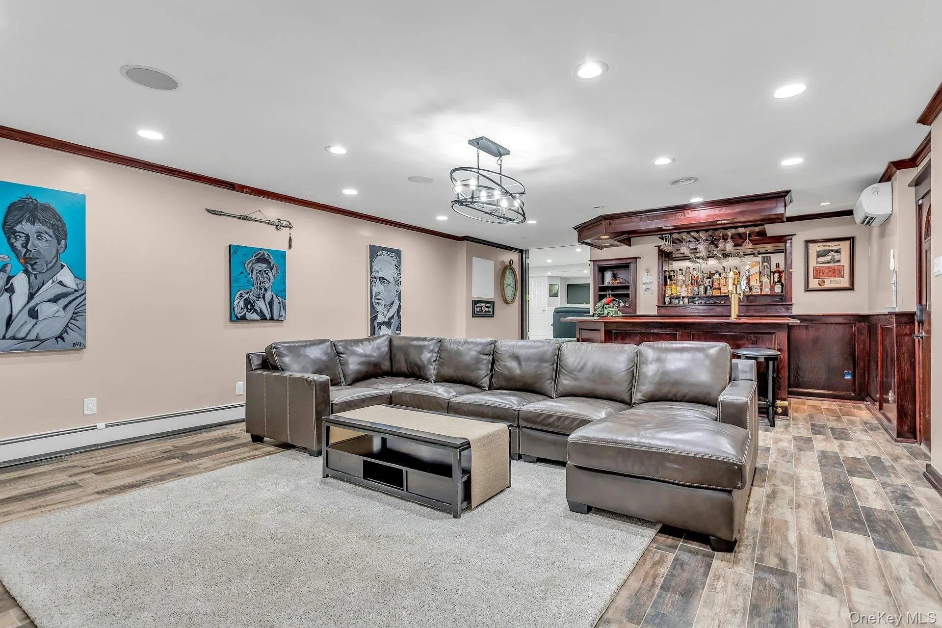 Living room featuring crown molding, light wood-style flooring, recessed lighting, an AC wall unit, and a bar Living room featuring crown molding, light wood-style flooring, recessed lighting, an AC wall unit, and a bar