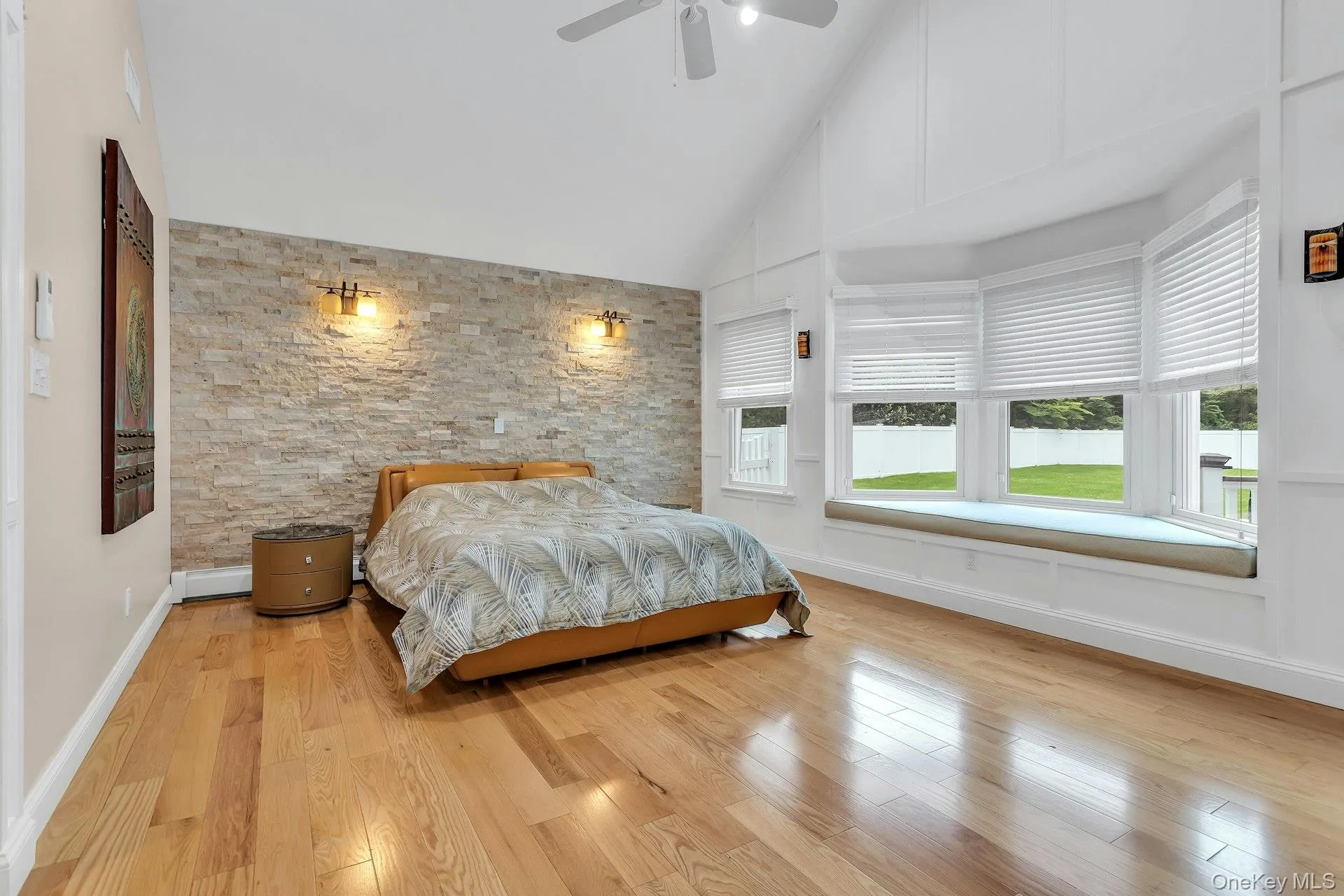 Bedroom with multiple windows, wood finished floors, high vaulted ceiling, and ceiling fan Bedroom with multiple windows, wood finished floors, high vaulted ceiling, and ceiling fan