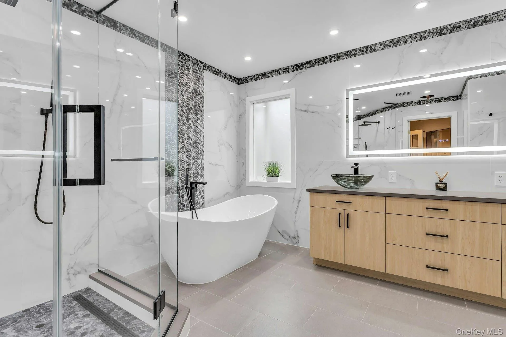 Full bathroom featuring vanity, a marble finish shower, and a freestanding bath Full bathroom featuring vanity, a marble finish shower, and a freestanding bath