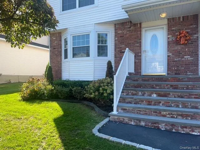 Doorway to property featuring a lawn and brick siding Doorway to property featuring a lawn and brick siding