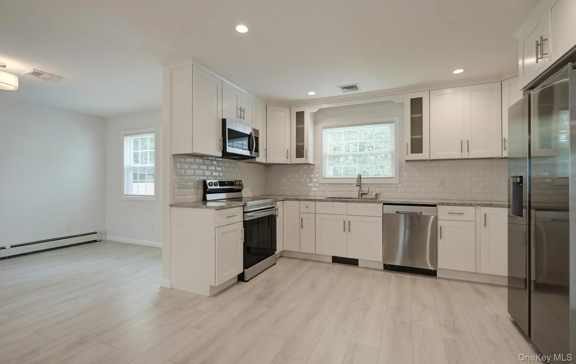 Kitchen with stainless steel appliances, a sink, light stone countertops, tasteful backsplash, and recessed lighting Kitchen with stainless steel appliances, a sink, light stone countertops, tasteful backsplash, and recessed lighting