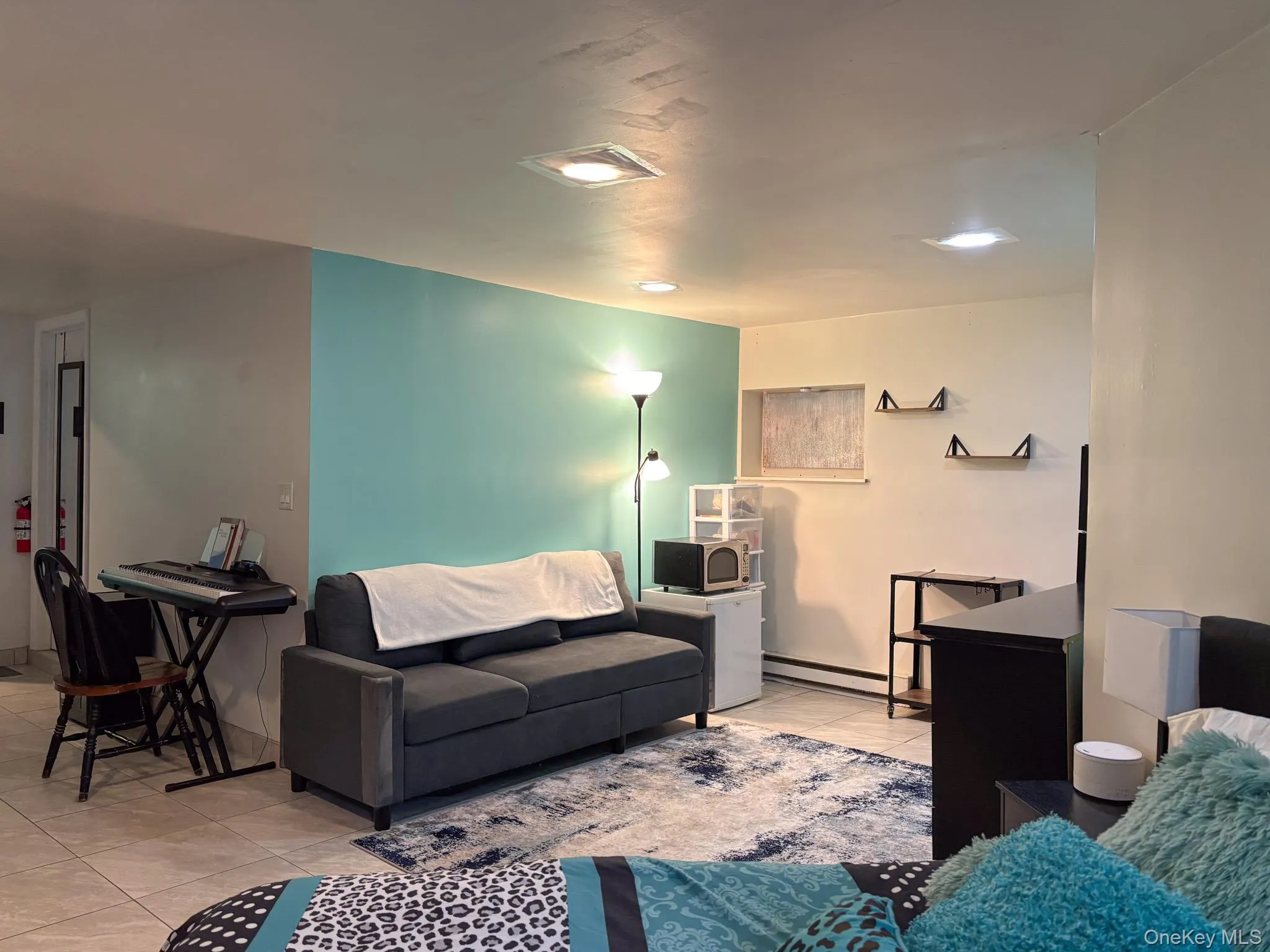 Basement featuring light tile patterned floors, baseboard heating, and recessed lighting Basement featuring light tile patterned floors, baseboard heating, and recessed lighting