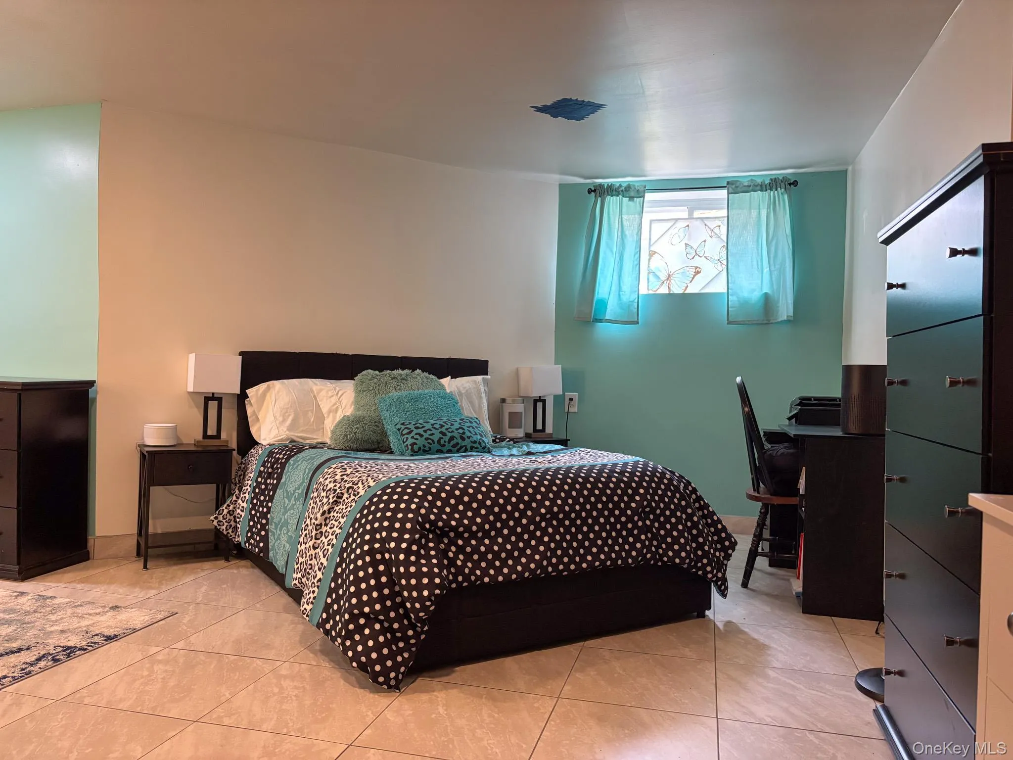 Basement currently used as a bedroom featuring tile patterned floors Basement currently used as a bedroom featuring tile patterned floors