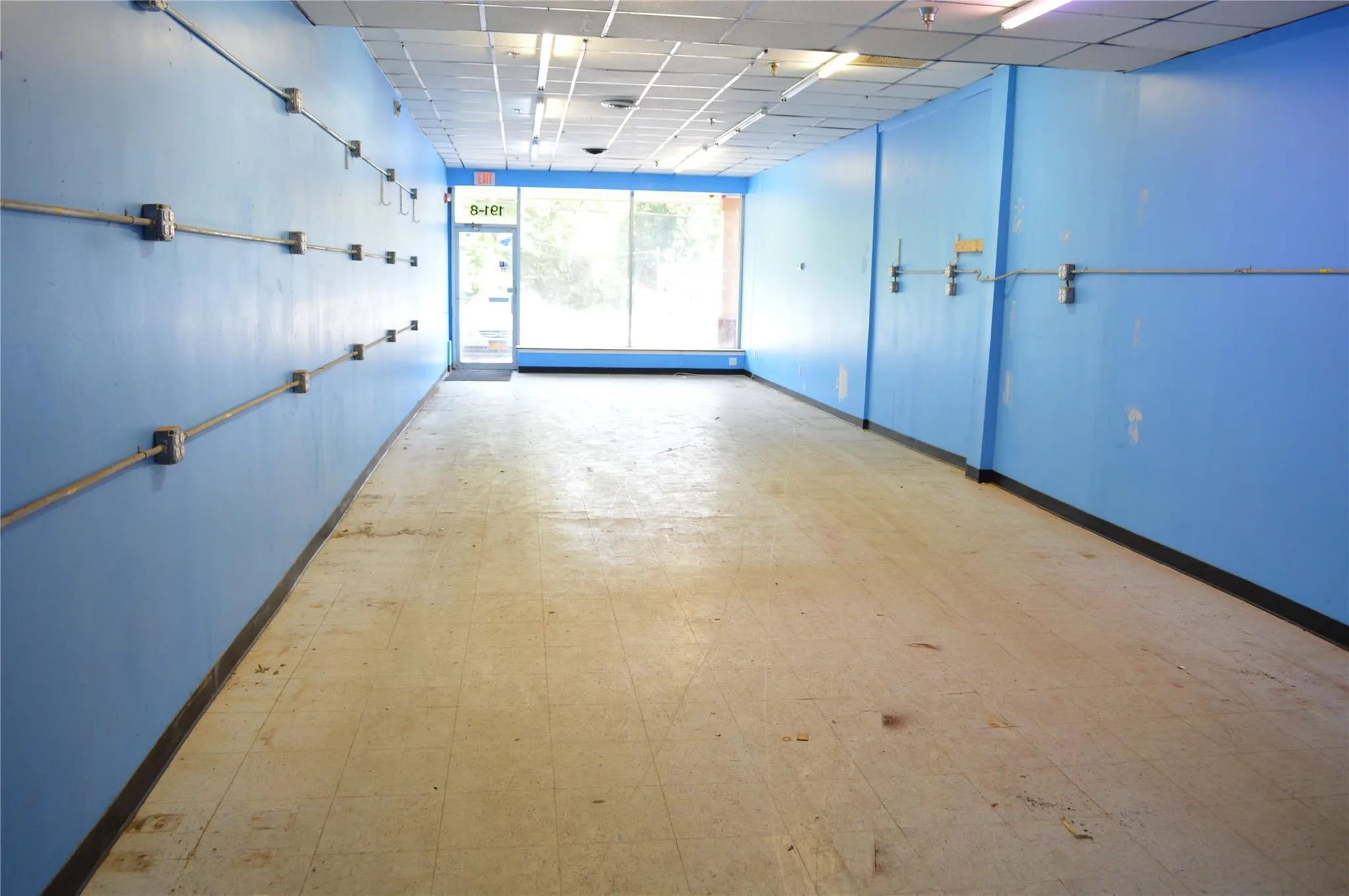 Spare room featuring baseboards, a paneled ceiling, and tile patterned floors Spare room featuring baseboards, a paneled ceiling, and tile patterned floors
