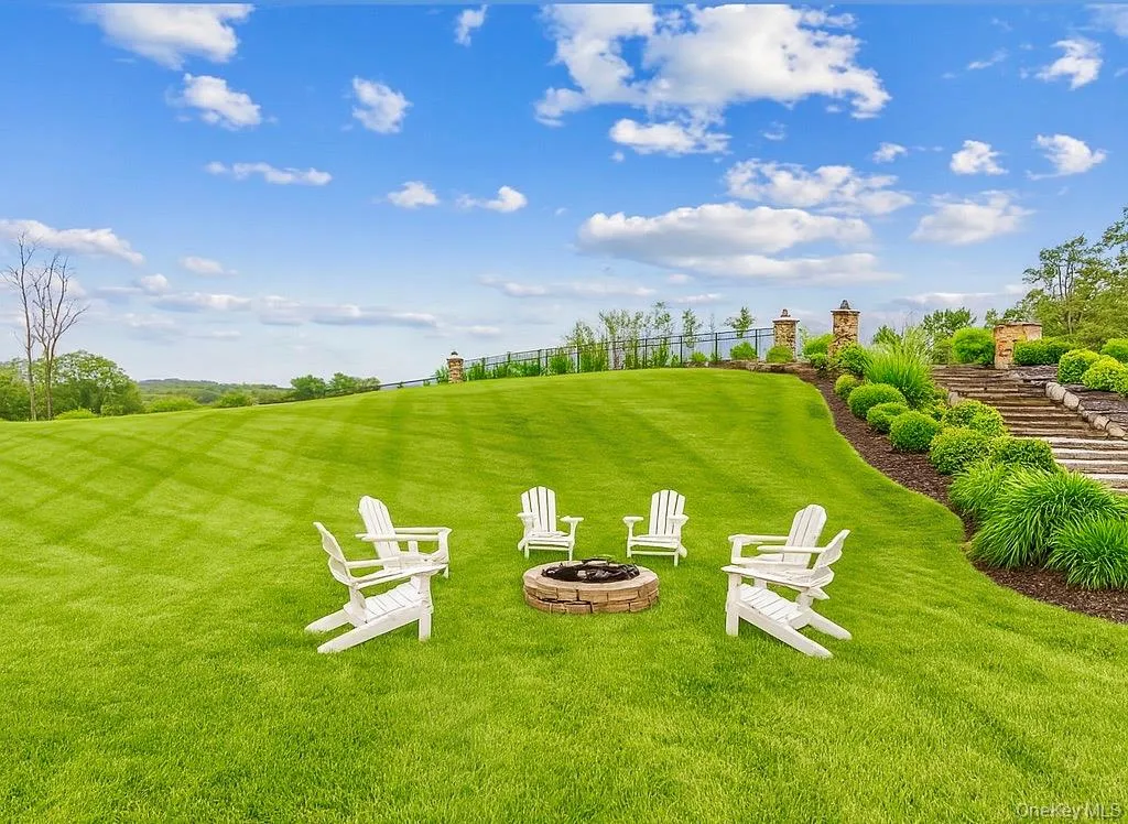 View of green lawn featuring a fire pit View of green lawn featuring a fire pit