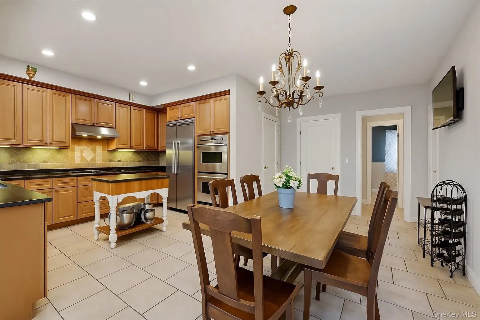 Dining room with light tile patterned flooring, recessed lighting, and a chandelier Dining room with light tile patterned flooring, recessed lighting, and a chandelier