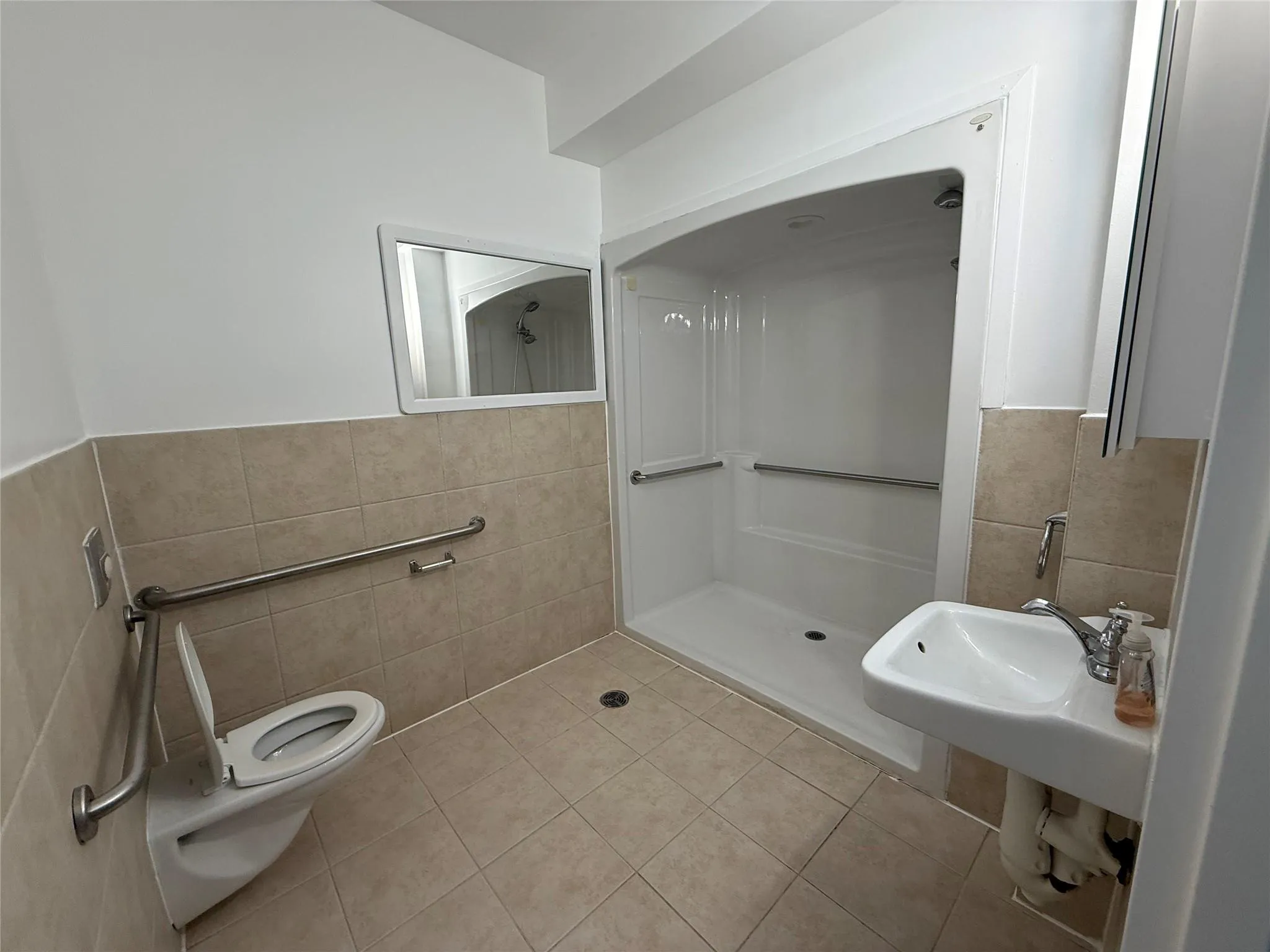 Bathroom featuring tile walls, a shower stall Bathroom featuring tile walls, a shower stall