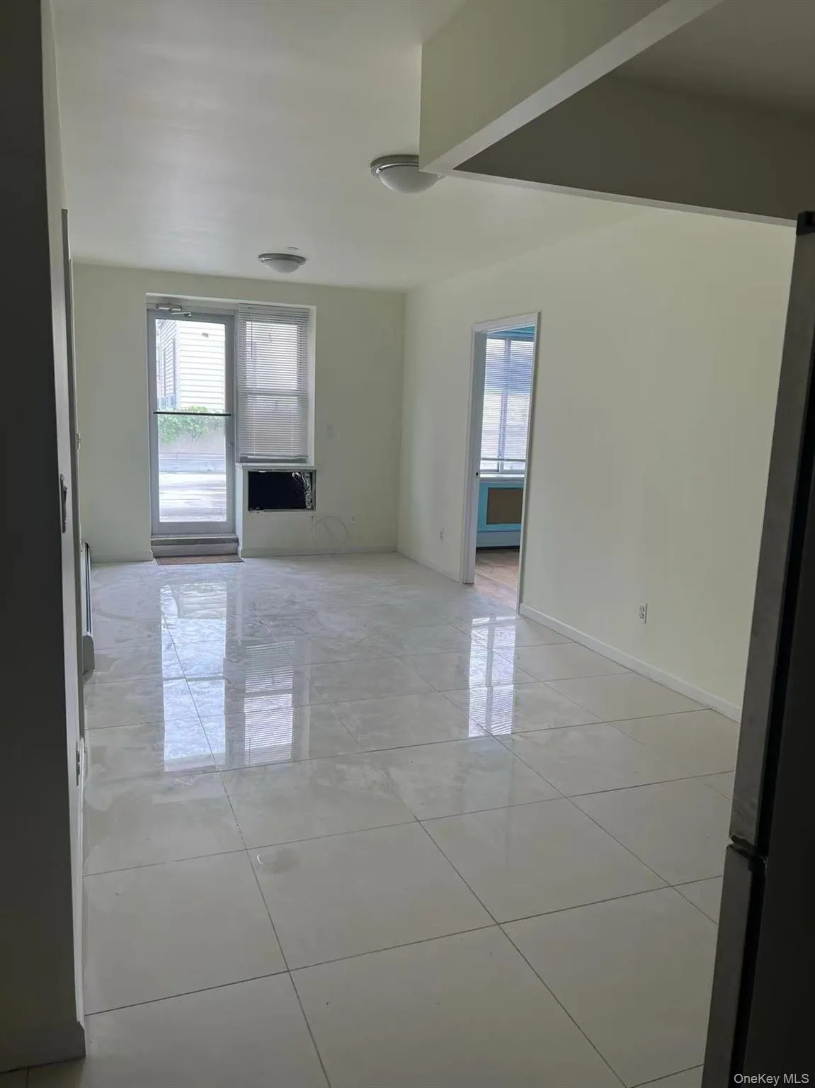 Empty room with plenty of natural light, light tile patterned flooring, and baseboards Empty room with plenty of natural light, light tile patterned flooring, and baseboards
