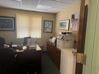 Home office with a drop ceiling, washer / dryer, and dark colored carpet Home office with a drop ceiling, washer / dryer, and dark colored carpet