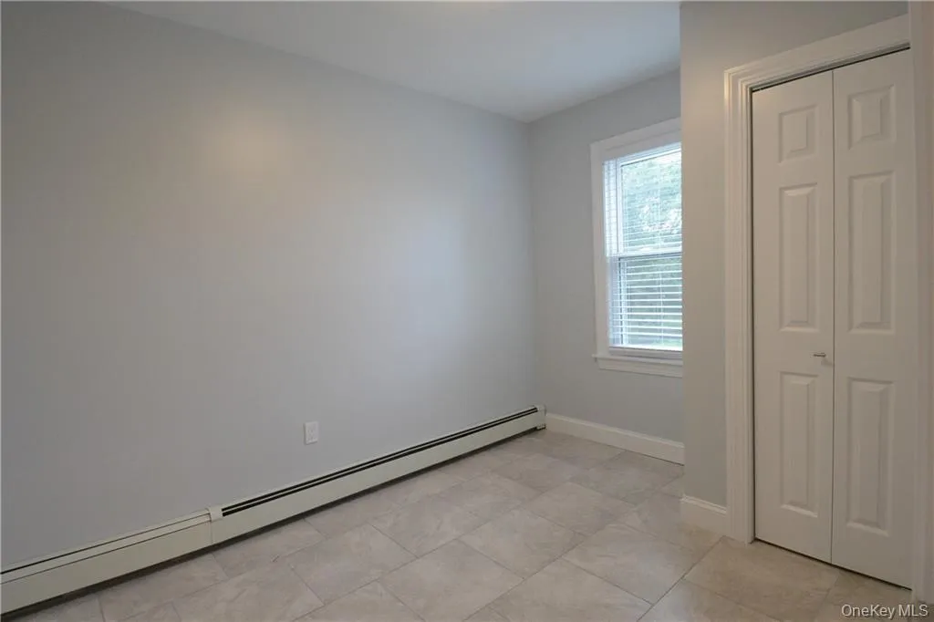 Empty room with baseboard heating and baseboards Empty room with baseboard heating and baseboards