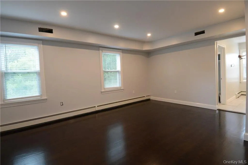 Spare room featuring a baseboard heating unit, a baseboard radiator, dark wood finished floors, plenty of natural light, and recessed lighting Spare room featuring a baseboard heating unit, a baseboard radiator, dark wood finished floors, plenty of natural light, and recessed lighting