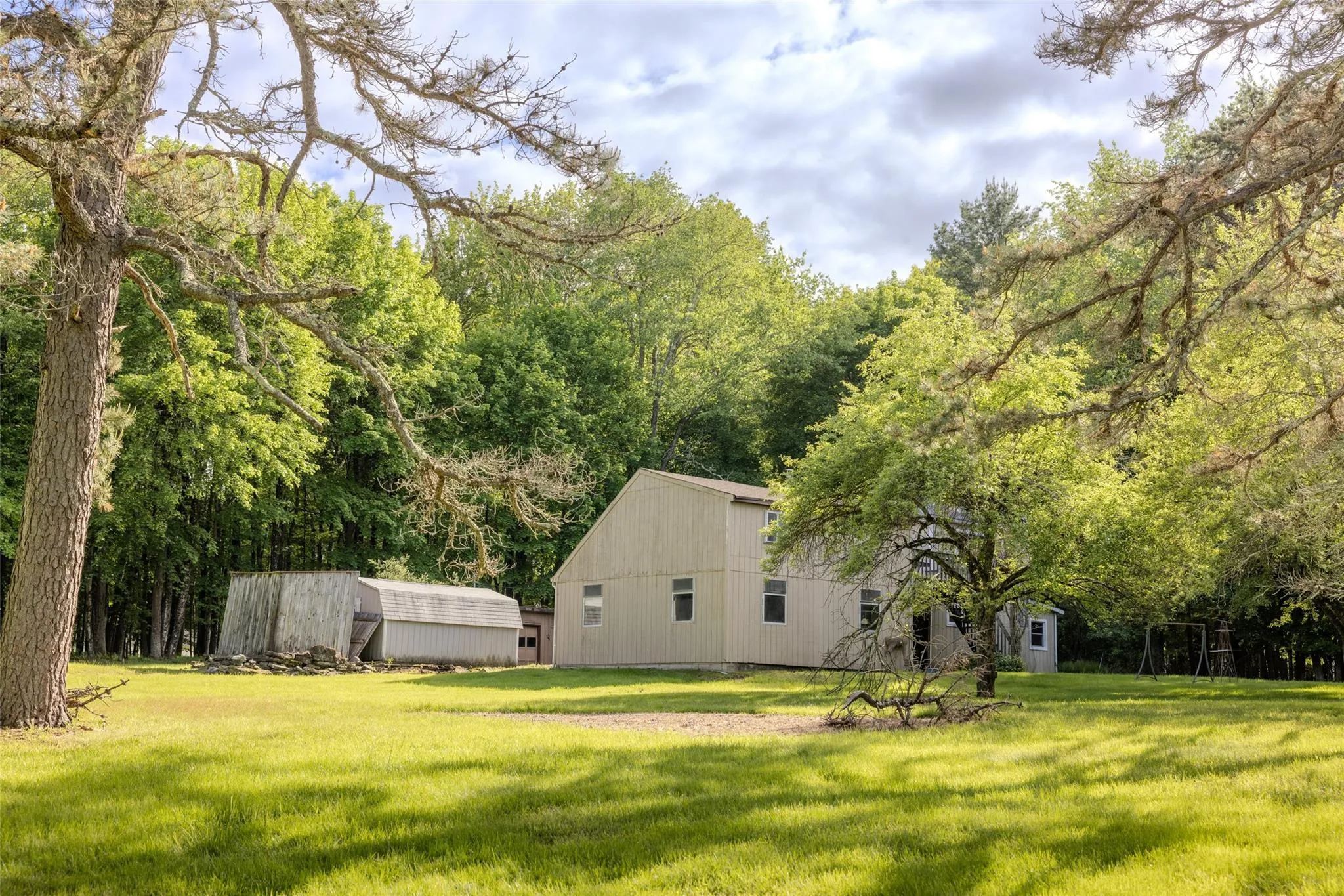 View of green lawn featuring an outdoor structure and an outbuilding View of green lawn featuring an outdoor structure and an outbuilding