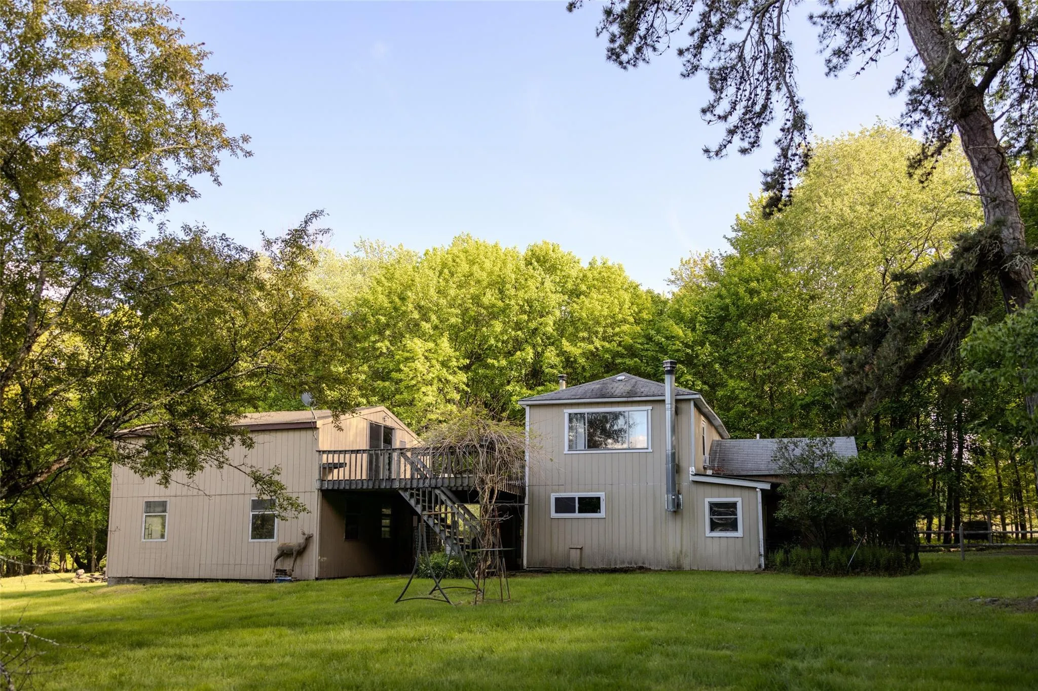 Rear view of property featuring stairs, a deck, and a yard Rear view of property featuring stairs, a deck, and a yard