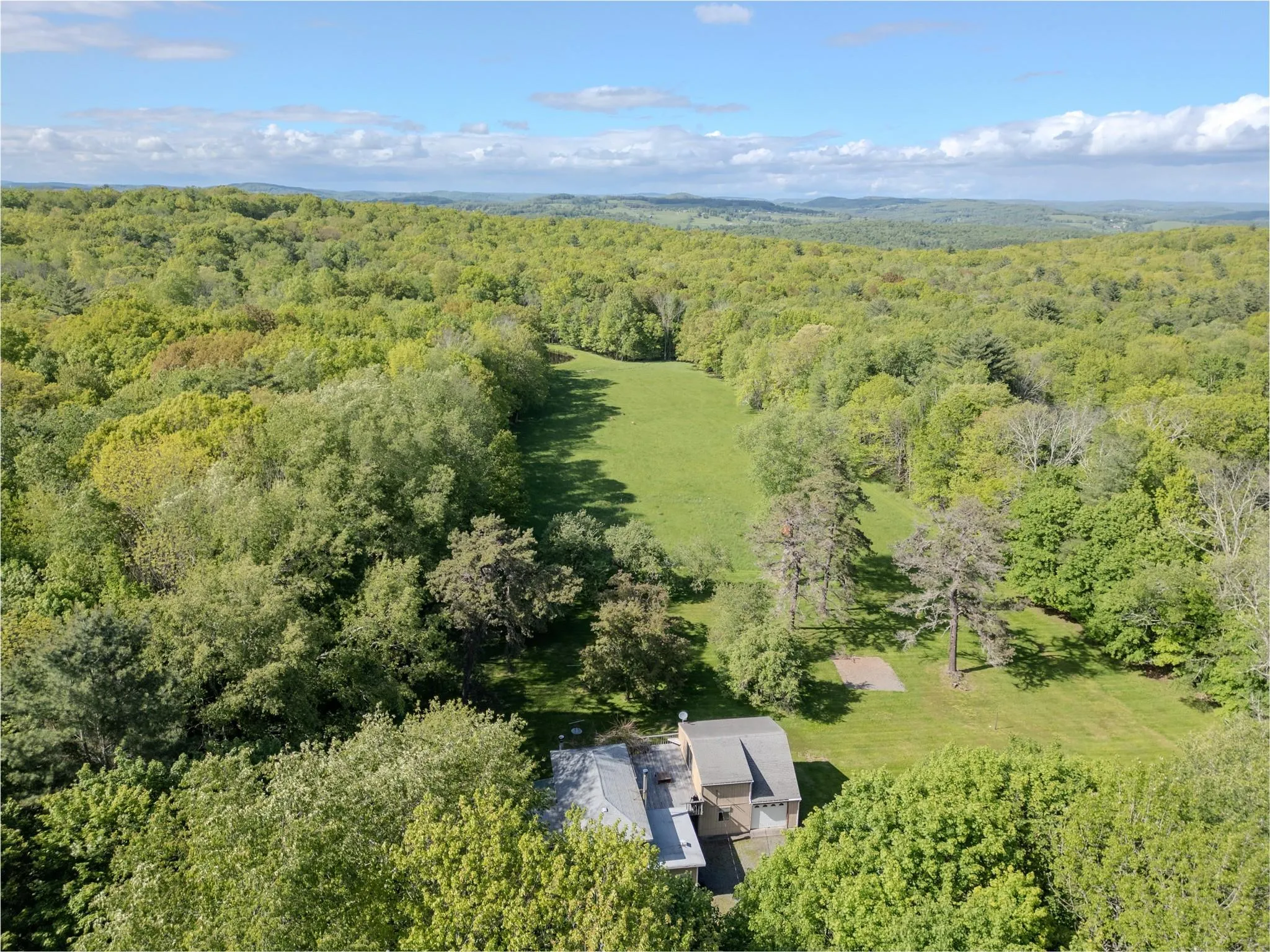 Aerial view of property and surrounding area featuring a heavily wooded area Aerial view of property and surrounding area featuring a heavily wooded area