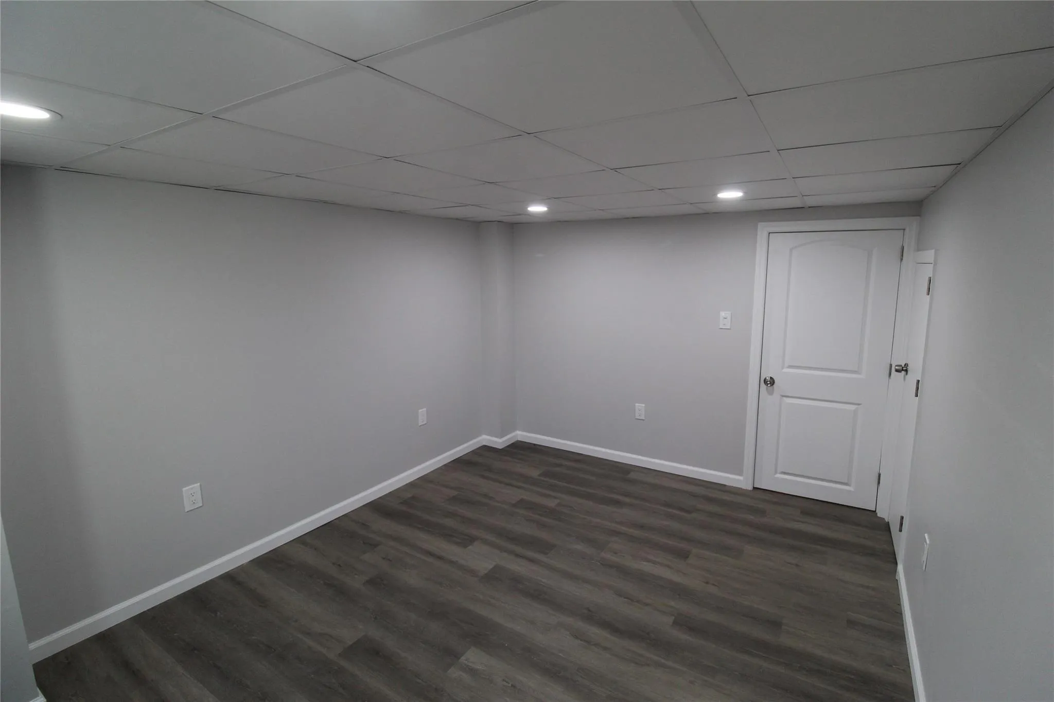 Spare room featuring dark wood finished floors, recessed lighting, baseboards, and a paneled ceiling Spare room featuring dark wood finished floors, recessed lighting, baseboards, and a paneled ceiling