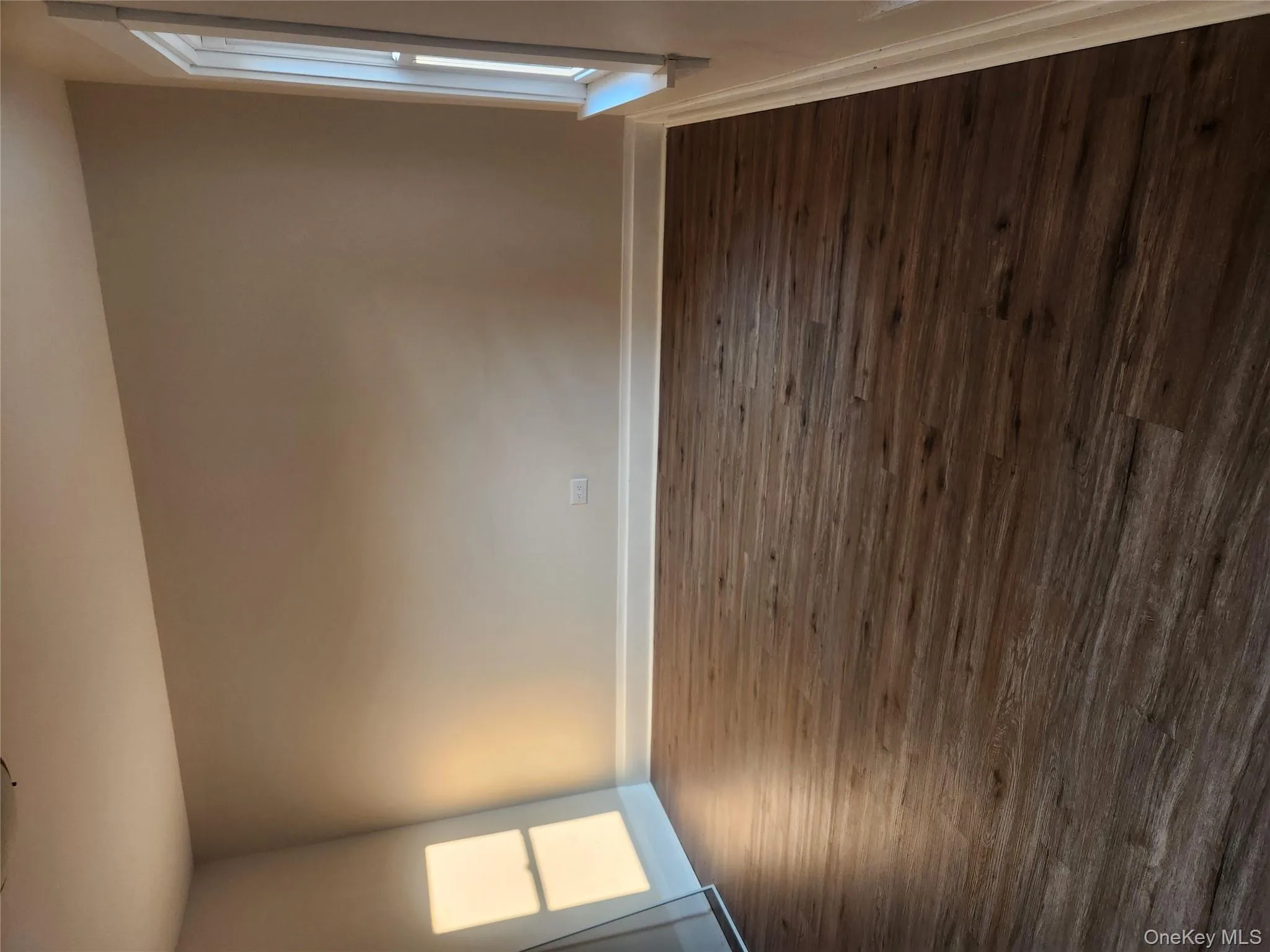 Spare room with baseboards and dark wood-style flooring Spare room with baseboards and dark wood-style flooring