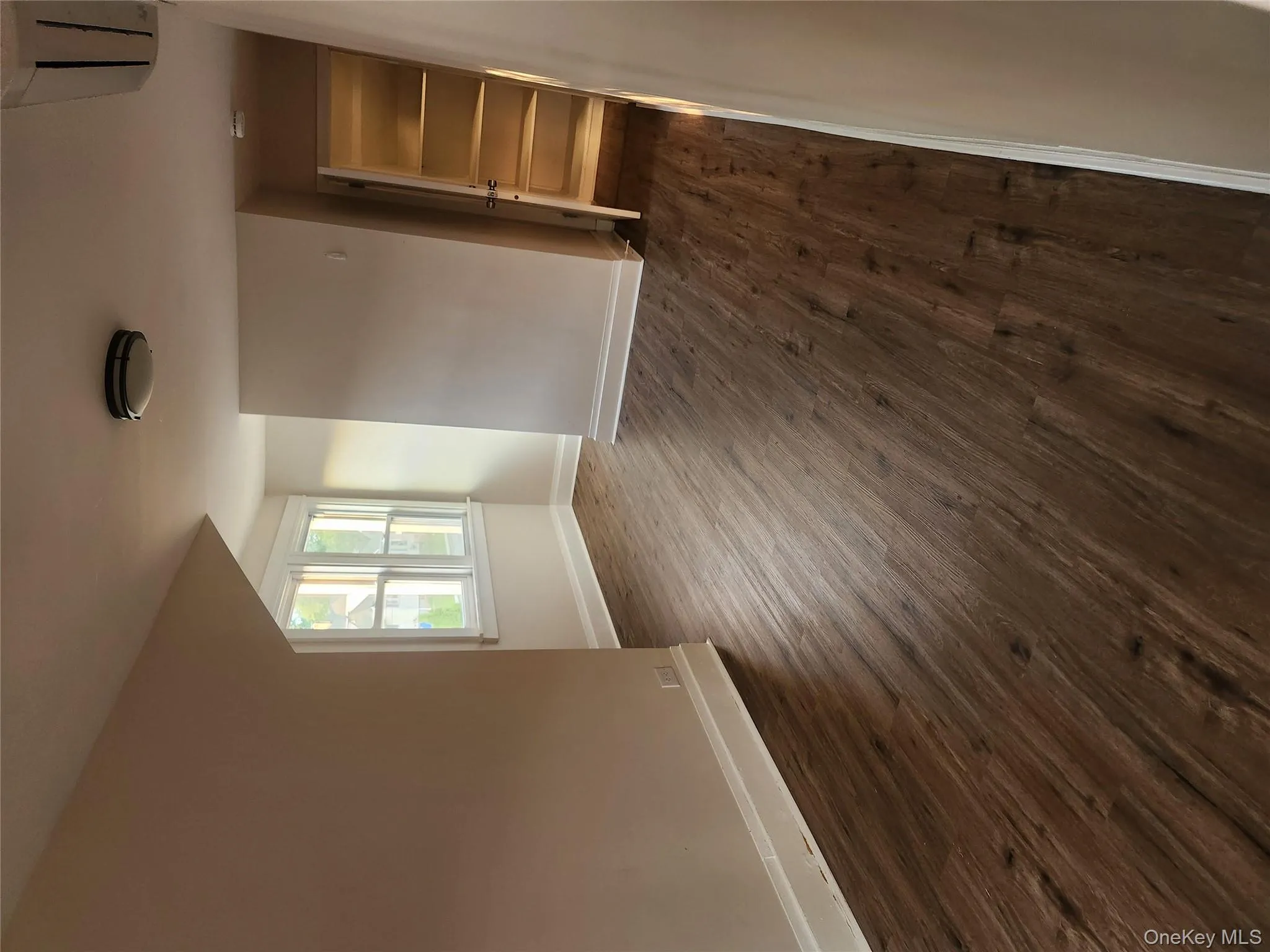 Spare room with baseboards and dark wood-type flooring Spare room with baseboards and dark wood-type flooring