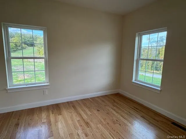 Spare room with baseboards and light wood-type flooring Spare room with baseboards and light wood-type flooring