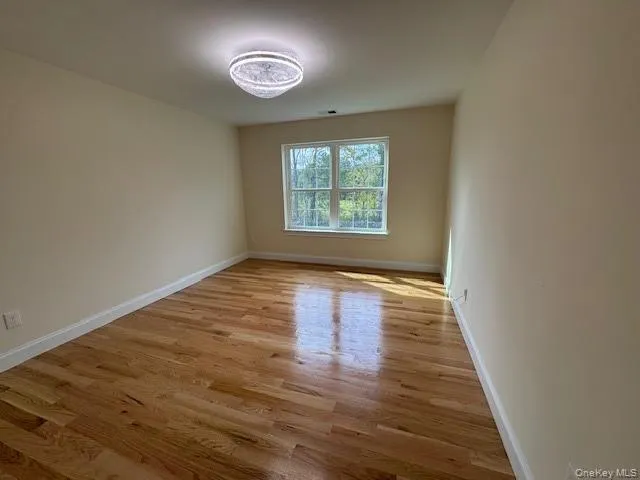 Spare room featuring light wood-style flooring and baseboards Spare room featuring light wood-style flooring and baseboards