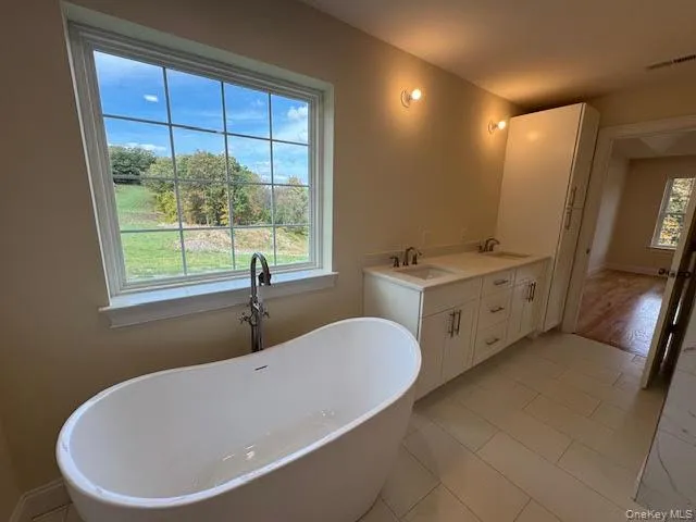 Full bath featuring a freestanding tub and double vanity Full bath featuring a freestanding tub and double vanity