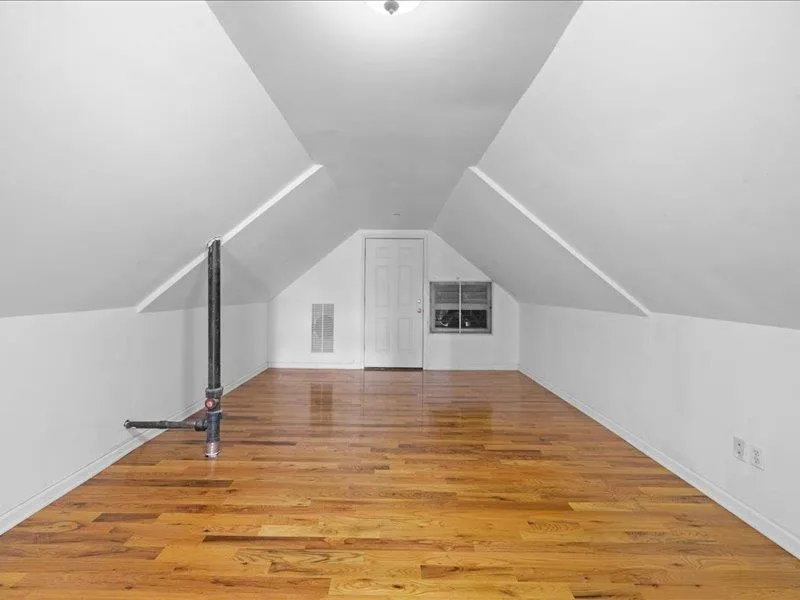 Additional living space with light wood finished floors, lofted ceiling, and baseboards Additional living space with light wood finished floors, lofted ceiling, and baseboards
