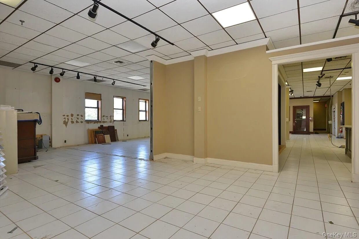 Spare room with rail lighting, a paneled ceiling, and baseboards Spare room with rail lighting, a paneled ceiling, and baseboards