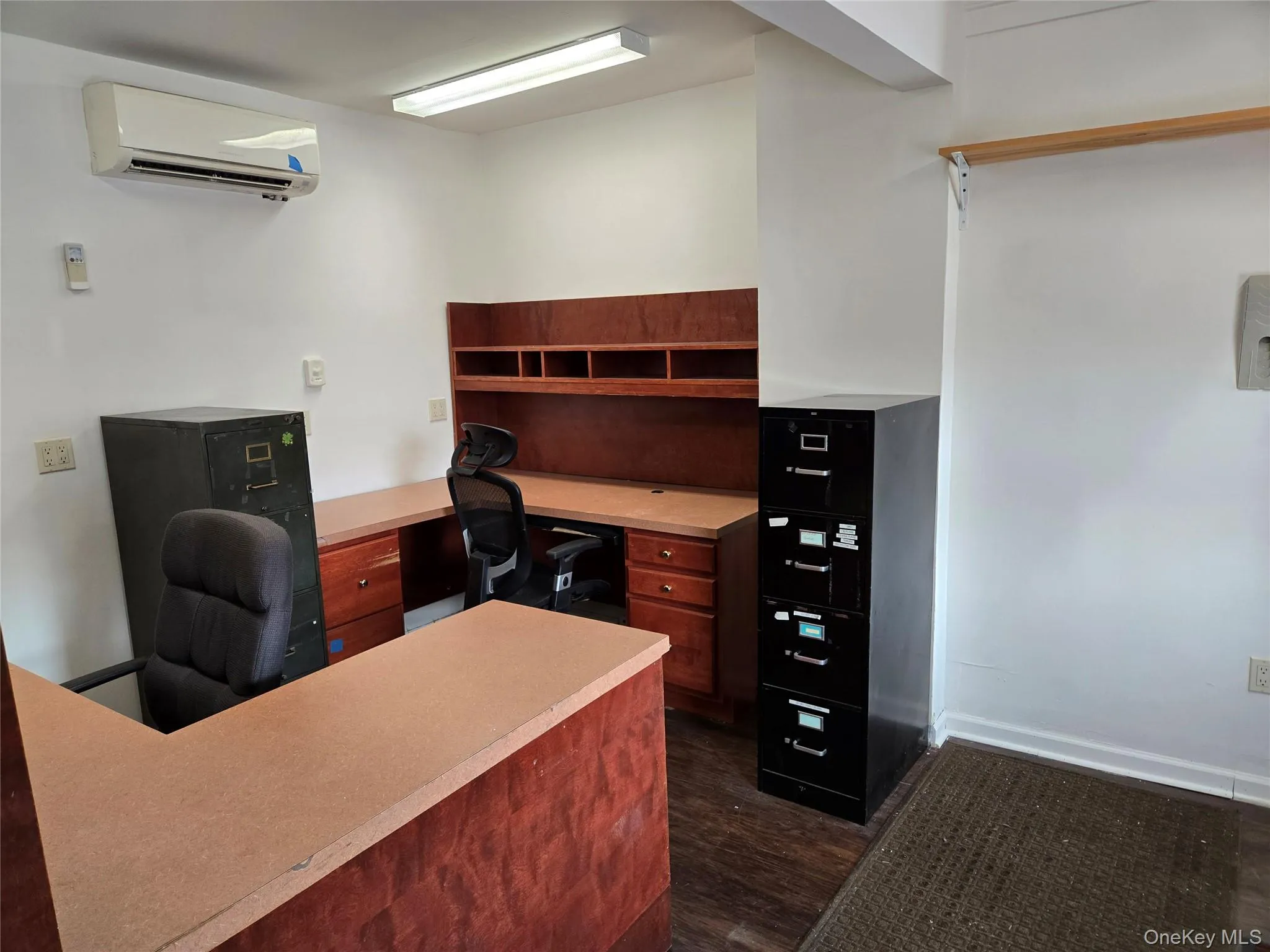 Office featuring an AC wall unit and dark wood-style flooring Office featuring an AC wall unit and dark wood-style flooring